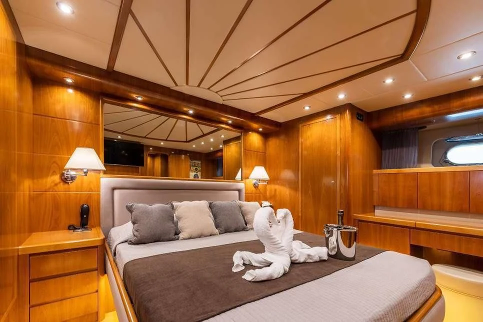 a bed with a white sheet and pillows on it aboard STAR LINK Yacht for Sale