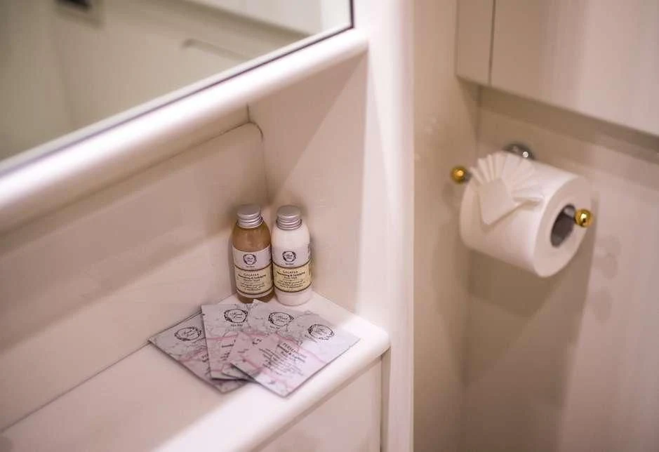 a bathroom with a toilet paper roll and cleaning supplies aboard STAR LINK Yacht for Sale