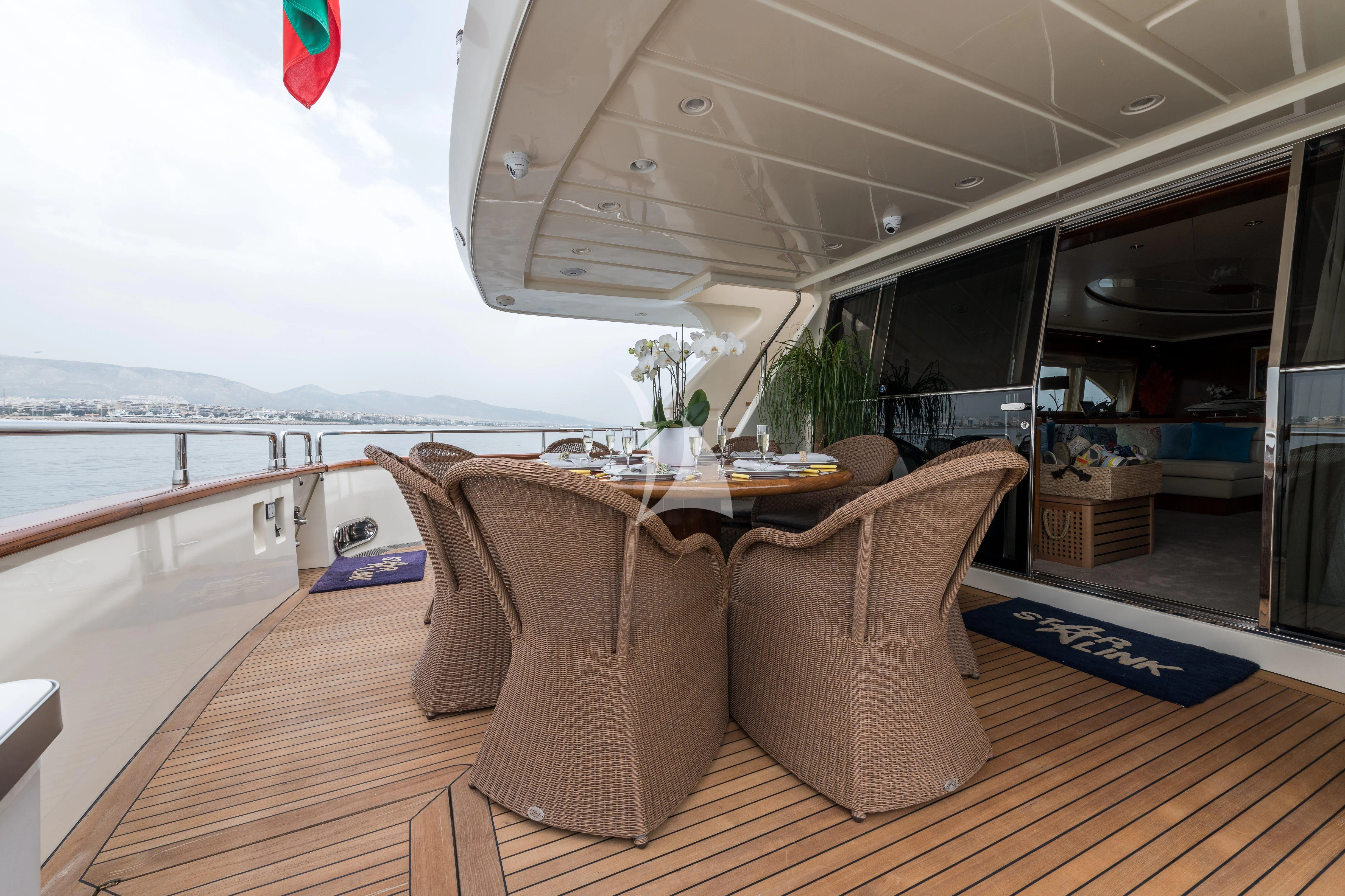 a table and chairs on a deck aboard STAR LINK Yacht for Sale