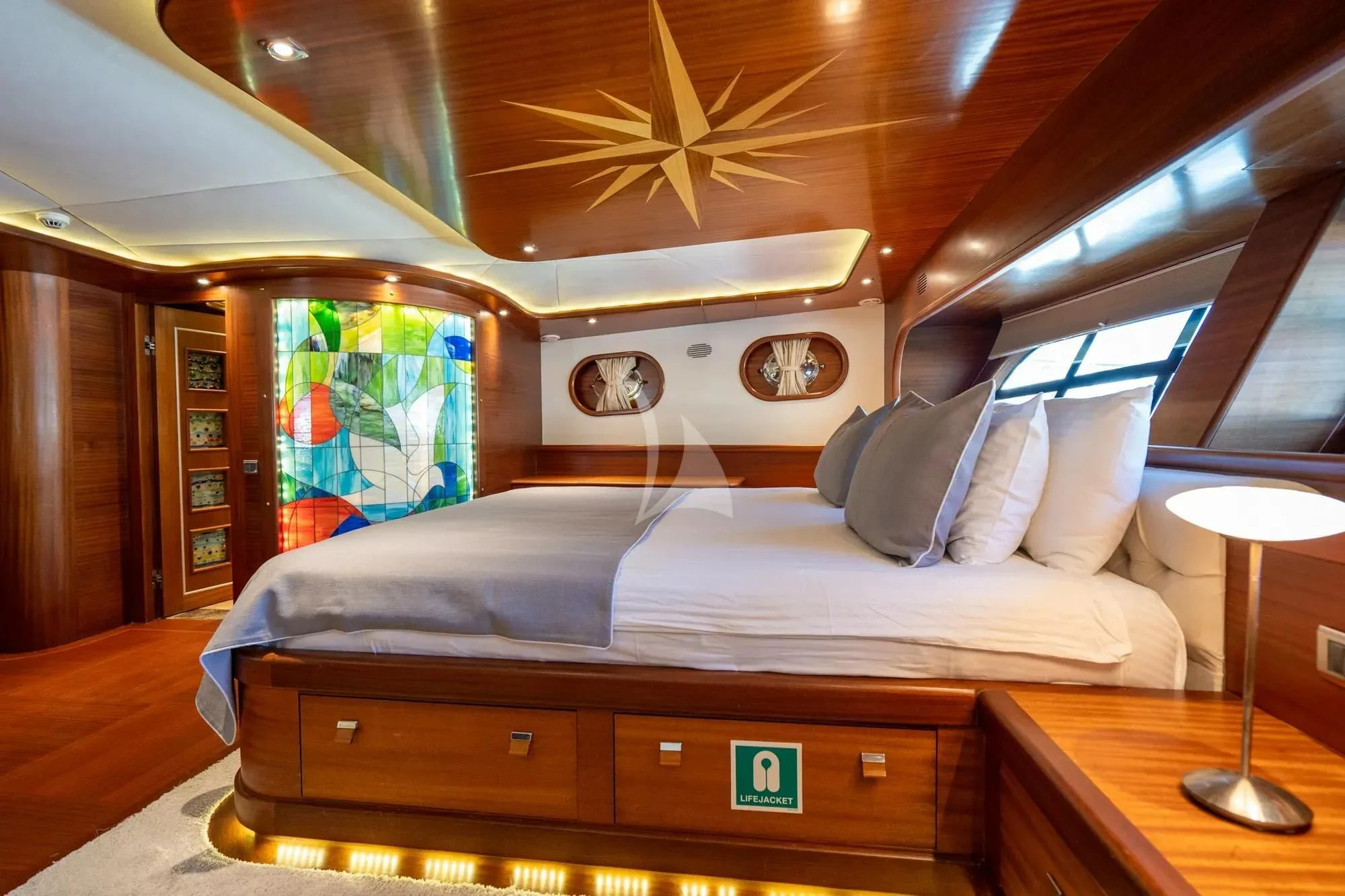 a bed with a painting on the wall aboard LA BELLA VITA Yacht for Sale
