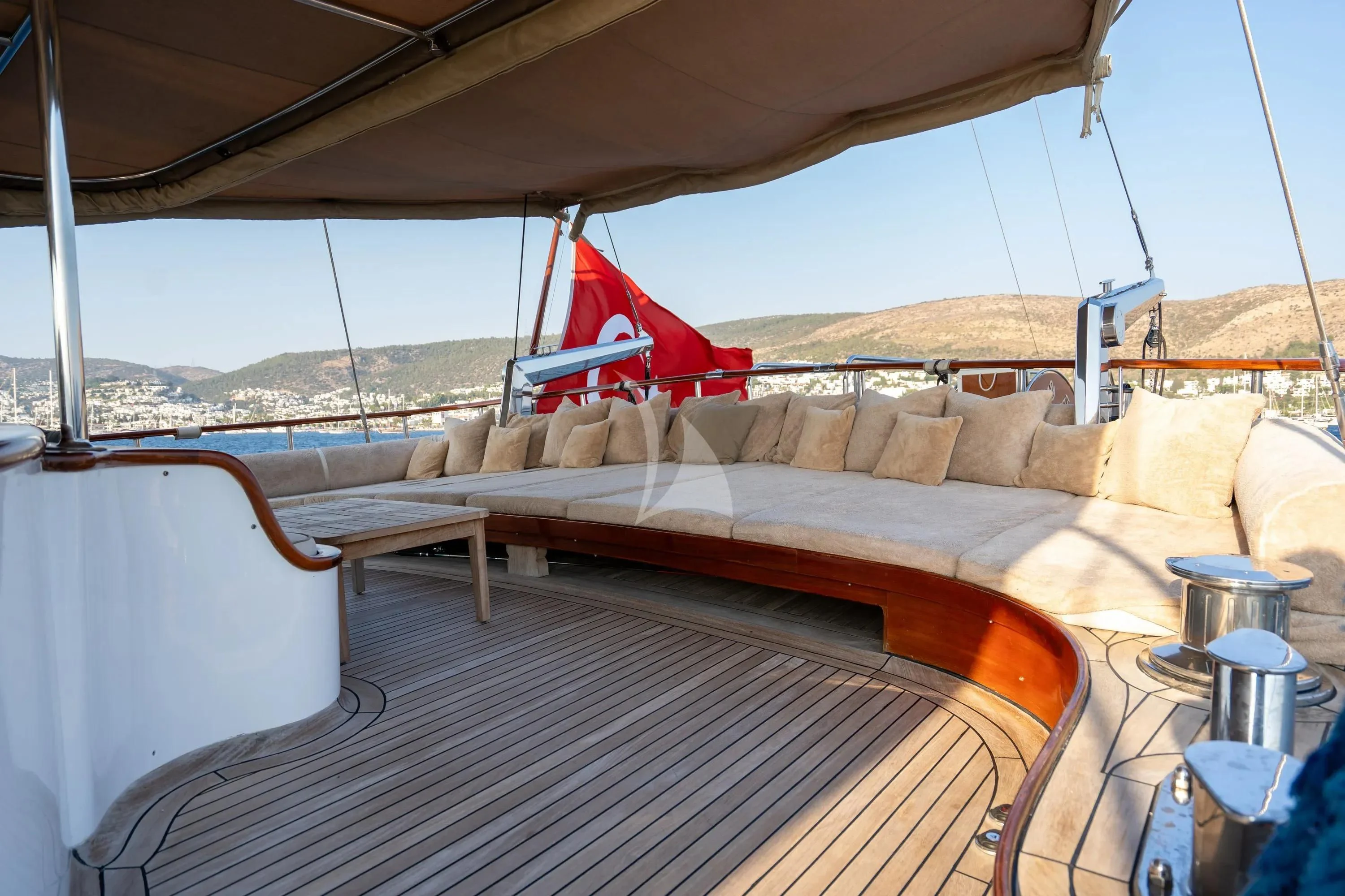 a deck with a bed and a red chair on it aboard LA BELLA VITA Yacht for Sale