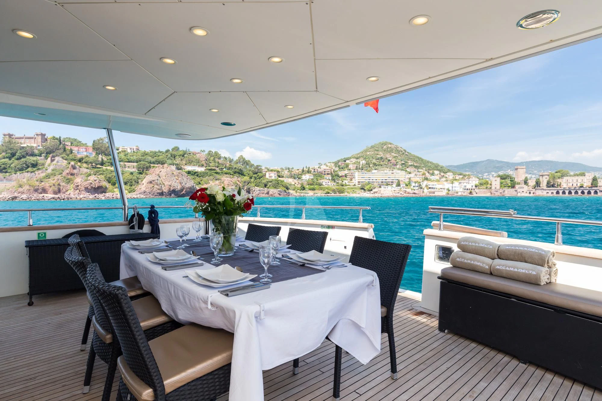 a table and chairs on a balcony overlooking a large body of water aboard ACCAMA DELTA Yacht for Sale