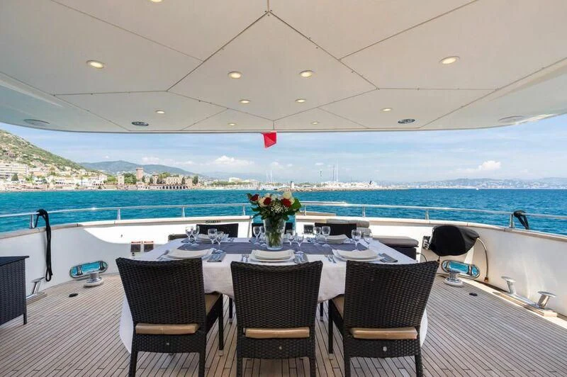 a table set for a meal on a balcony overlooking a large body of water aboard ACCAMA DELTA Yacht for Sale