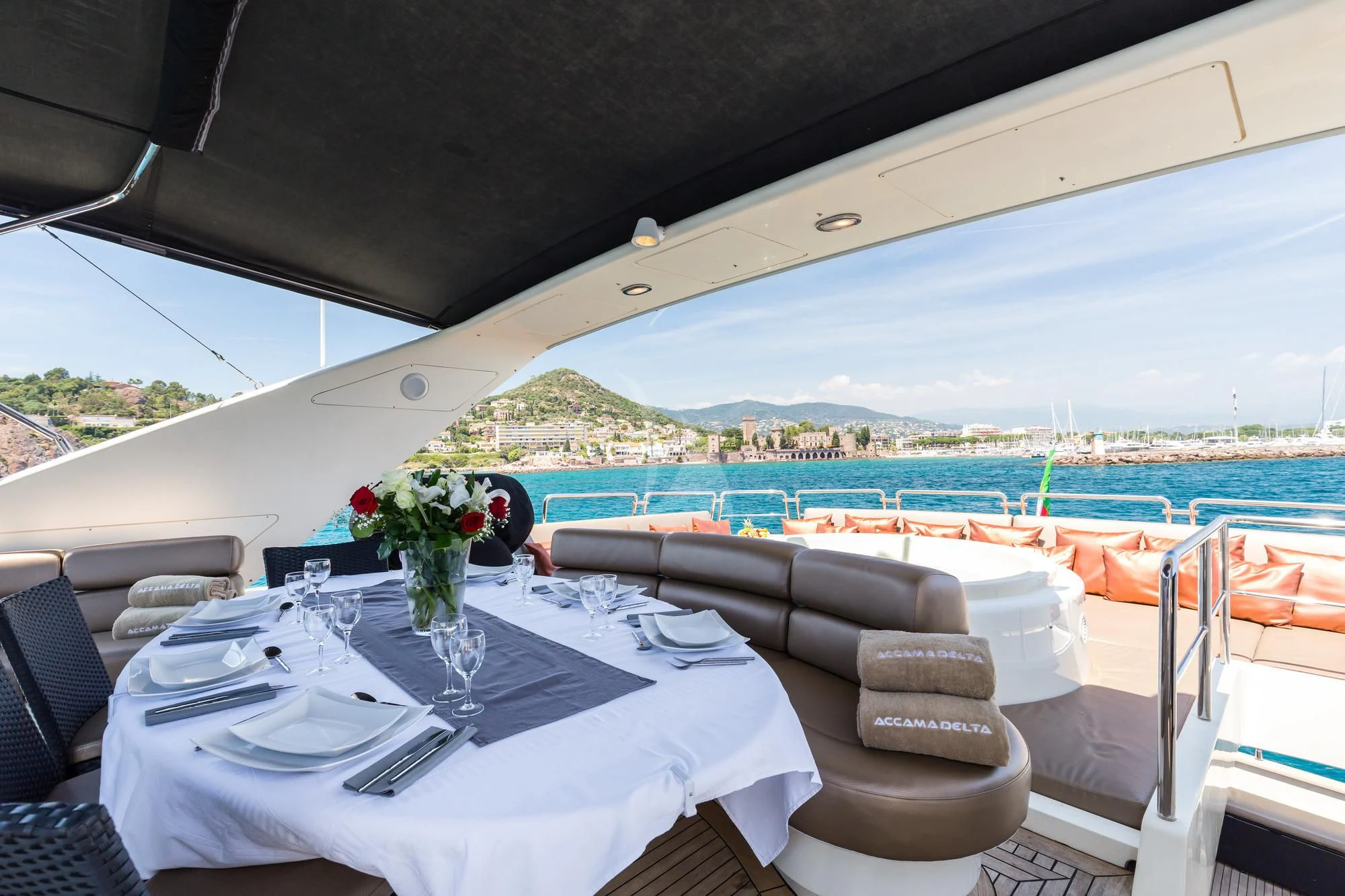 a table set for a dinner on a balcony overlooking a large body of water aboard ACCAMA DELTA Yacht for Sale