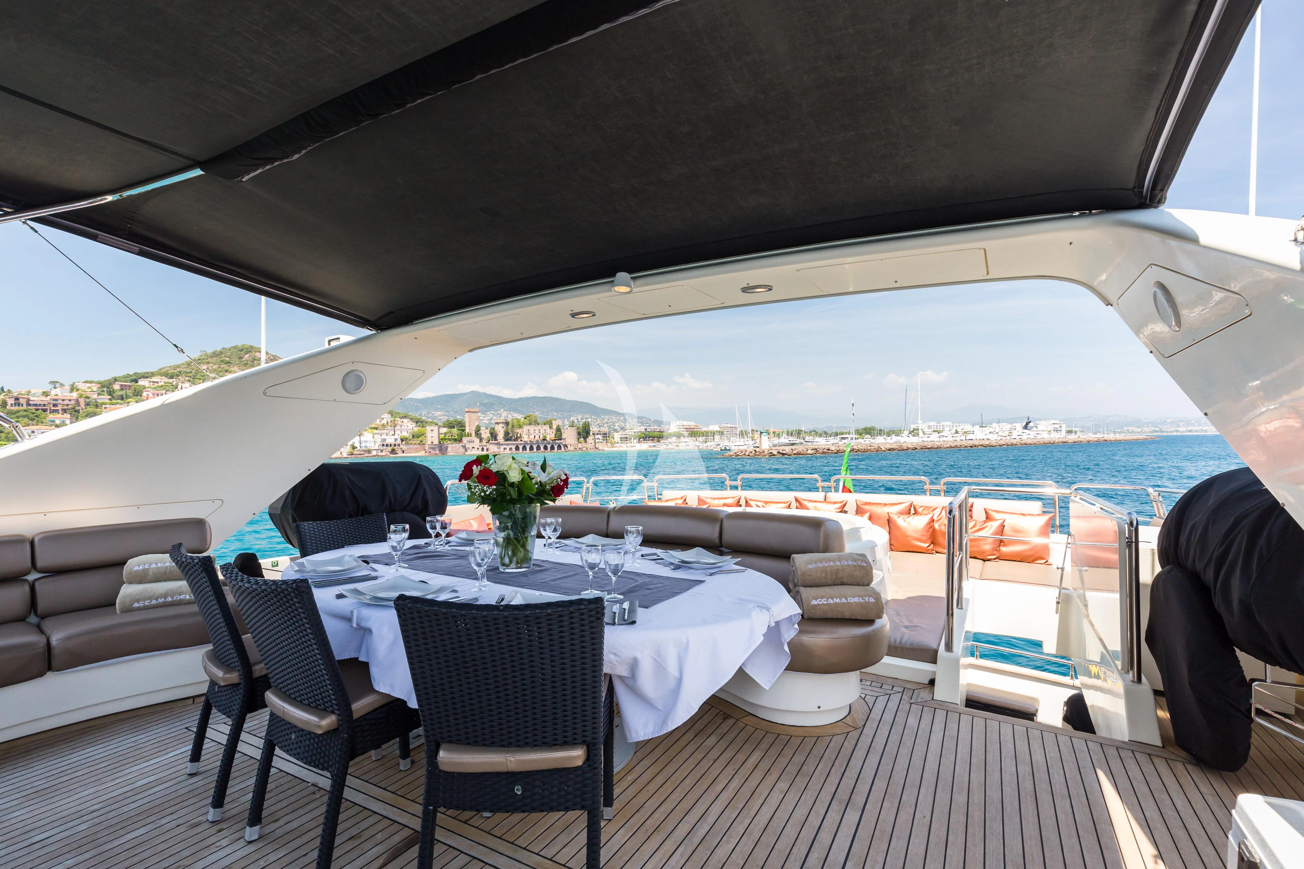 a table set for a meal on a deck overlooking a large body of water aboard ACCAMA DELTA Yacht for Sale