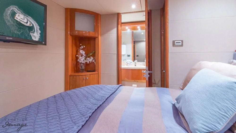 a bed with a blue comforter aboard CHIP Yacht for Sale