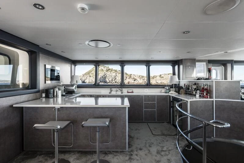 a kitchen with a bar and stools aboard OURWAY Yacht for Sale