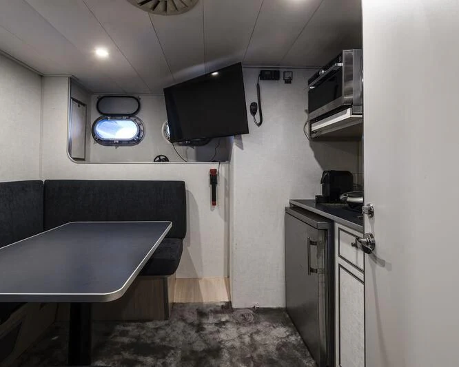 a small kitchen with a bar and tv aboard OURWAY Yacht for Sale