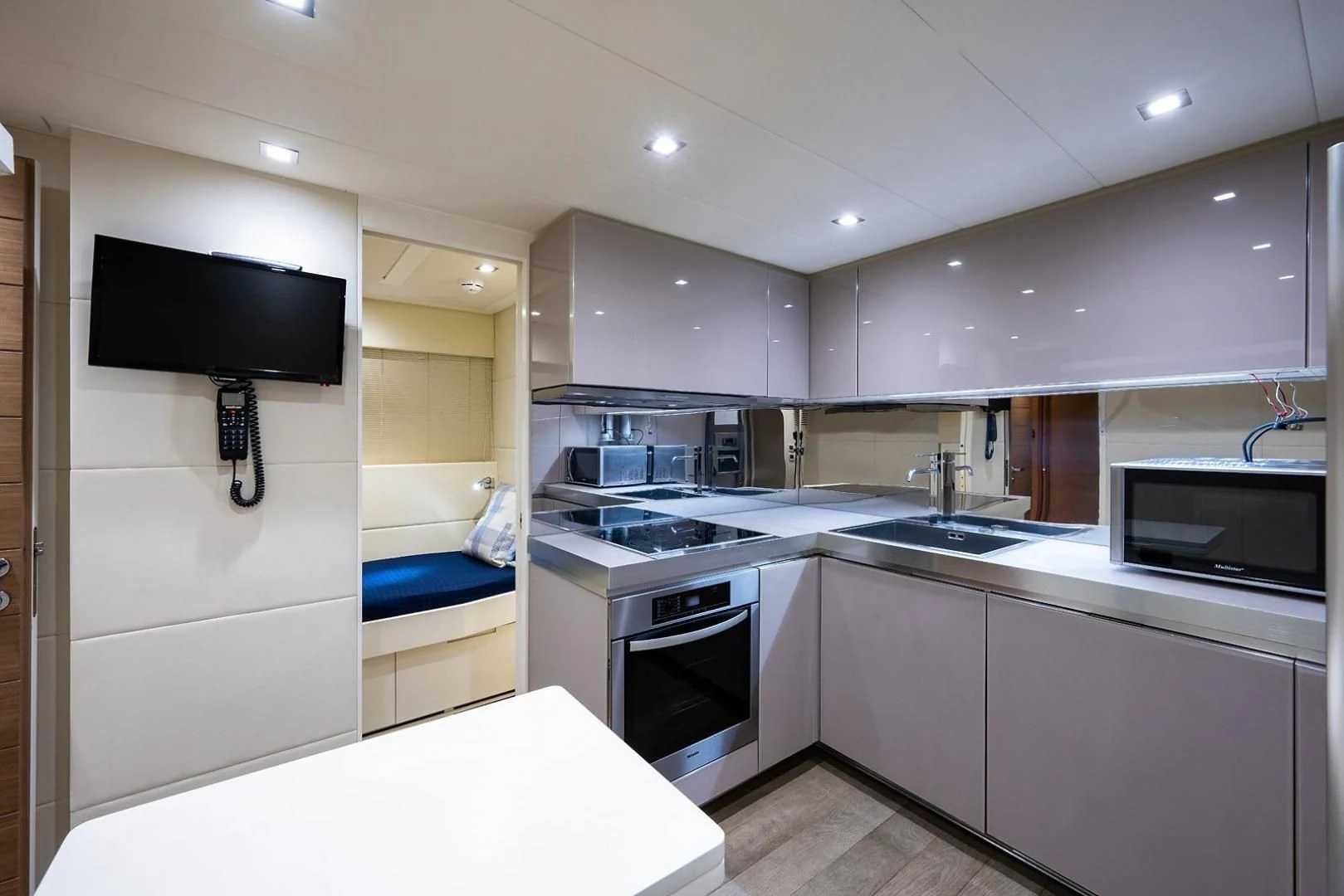 a kitchen with a tv and a bed aboard CLAIMS TO FAME Yacht for Sale