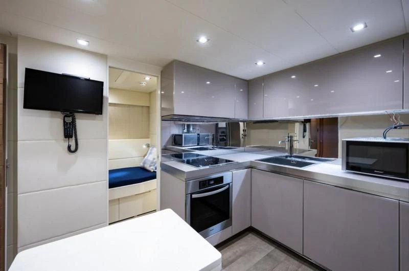 a kitchen with a bed and a tv aboard CLAIMS TO FAME Yacht for Sale