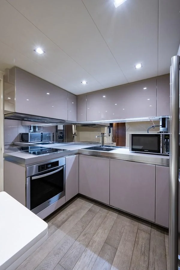 a kitchen with white cabinets aboard CLAIMS TO FAME Yacht for Sale