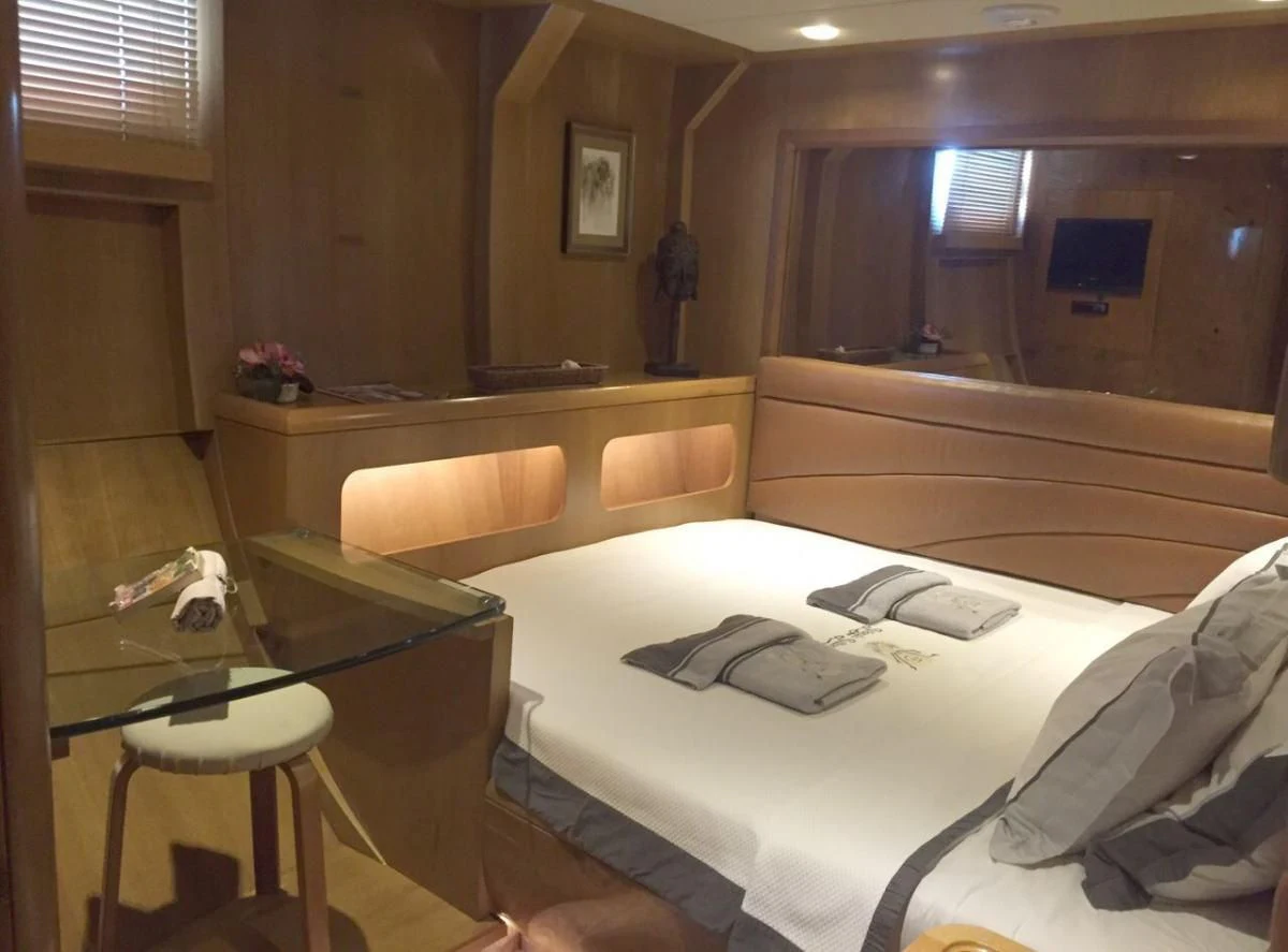 a room with a bed and desk aboard SUHEYLA SULTAN Yacht for Sale
