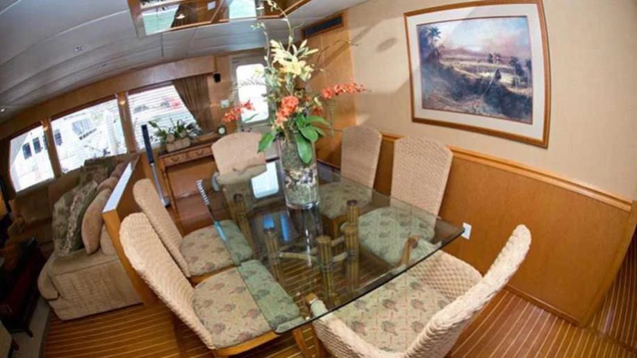 a dining room table with chairs and flowers aboard SHERAZADE Yacht for Sale