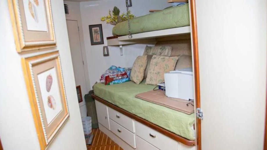 a bed with a green cover aboard SHERAZADE Yacht for Sale