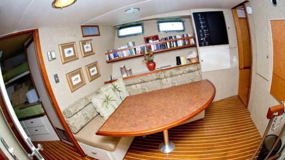 a kitchen with a table and a bench aboard SHERAZADE Yacht for Sale