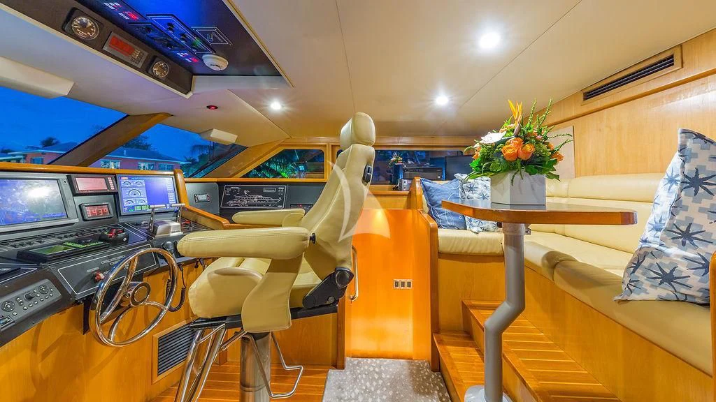 a person sitting in a chair in a room with a table and tv aboard ALEXANDRA JANE Yacht for Sale