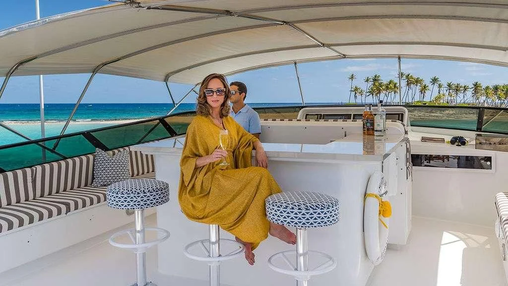 a man and woman sitting on a white lounge chair aboard ALEXANDRA JANE Yacht for Sale