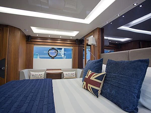 a bed with blue pillows aboard X-ELEVEN Yacht for Sale