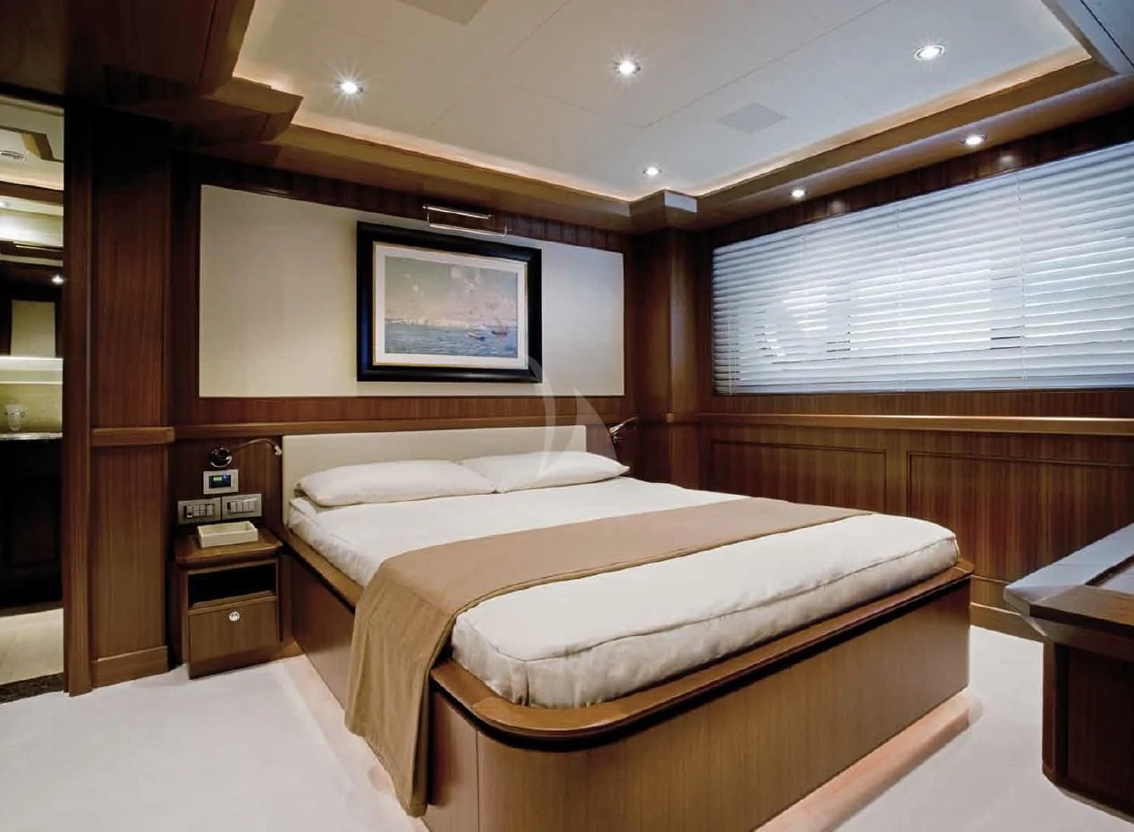 a room with a bed and a table aboard O'LION Yacht for Sale