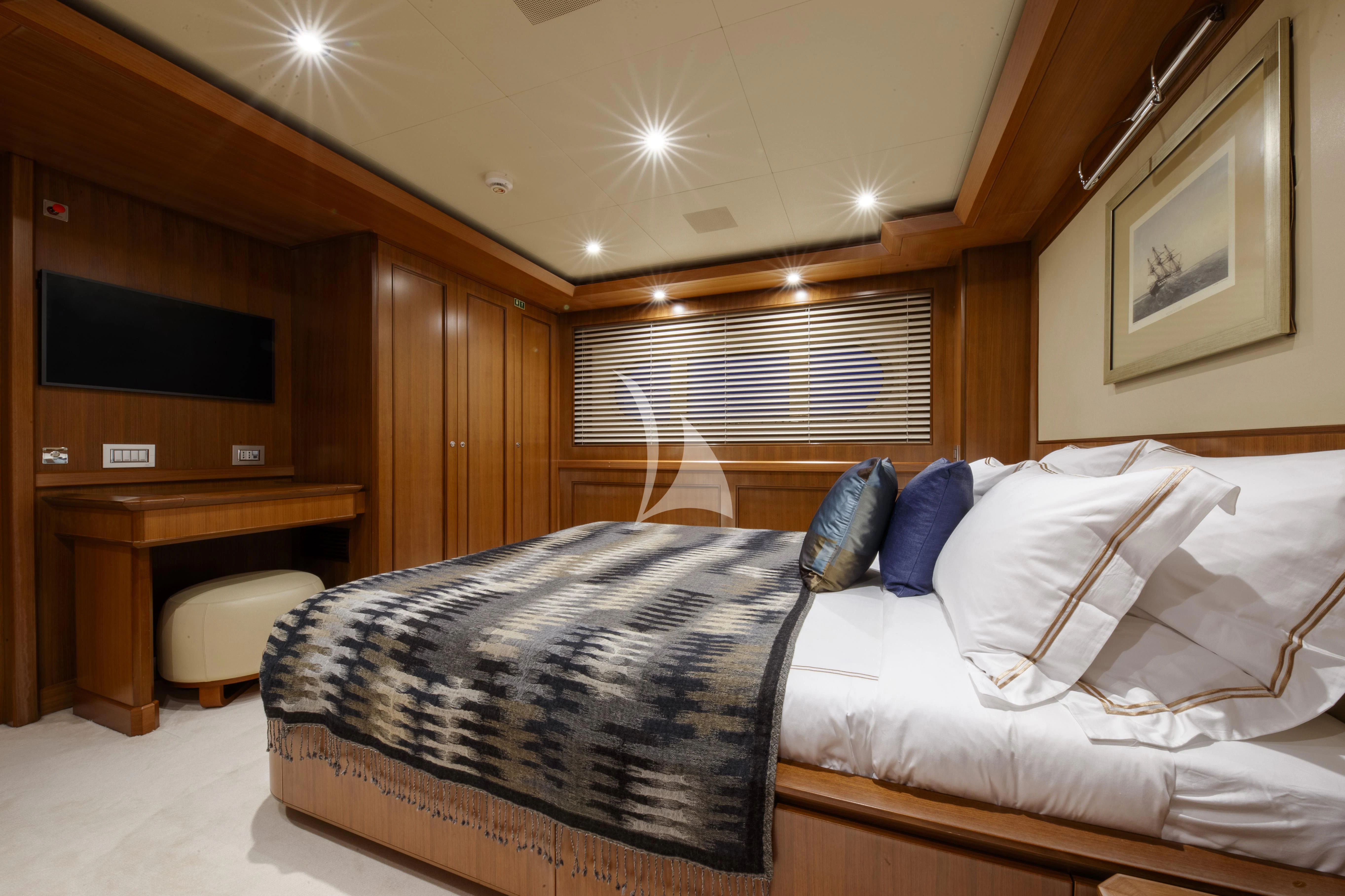 a bed with a blue and white comforter and pillows aboard O'LION Yacht for Sale