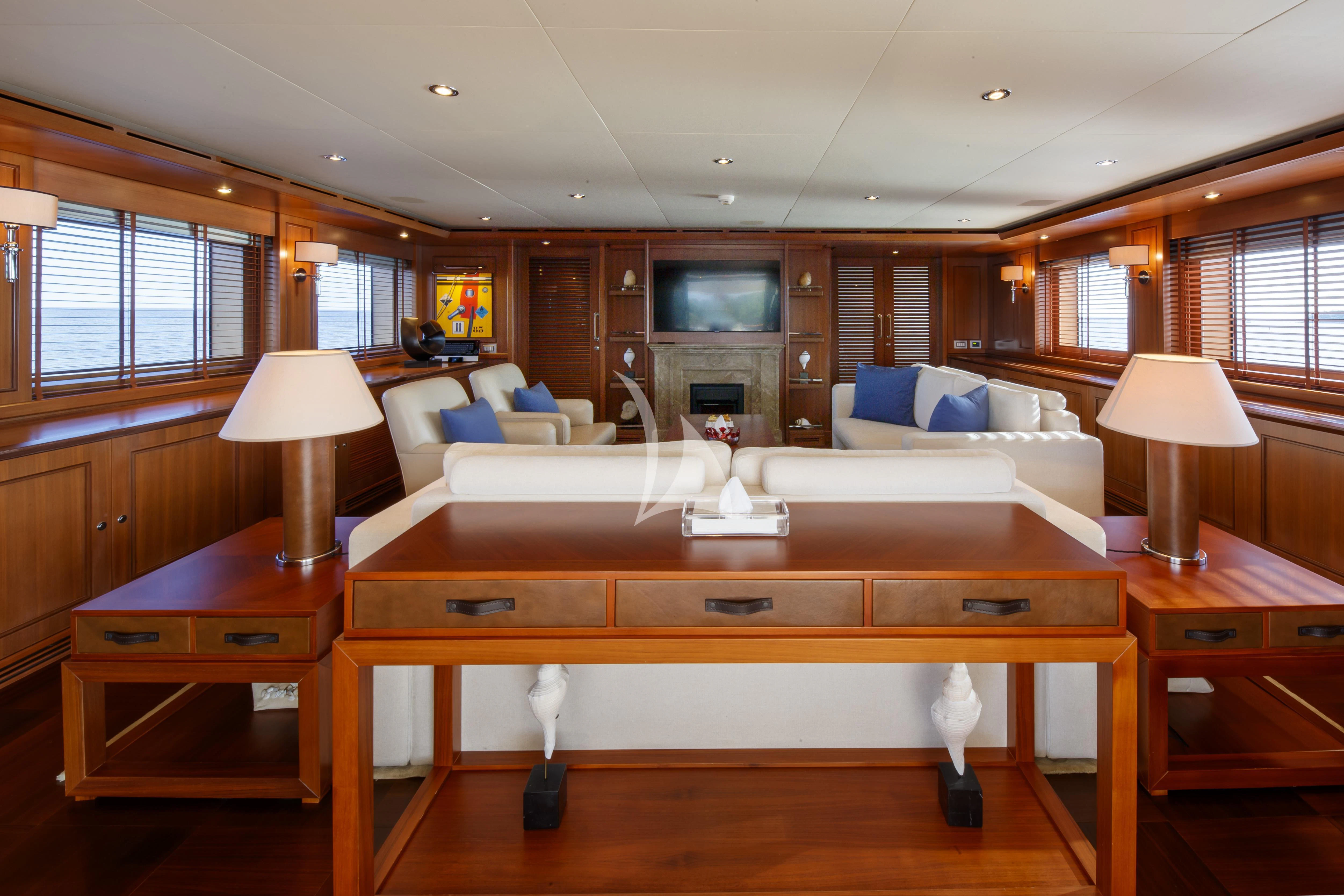 a living room with a large wood desk and a large window aboard O'LION Yacht for Sale