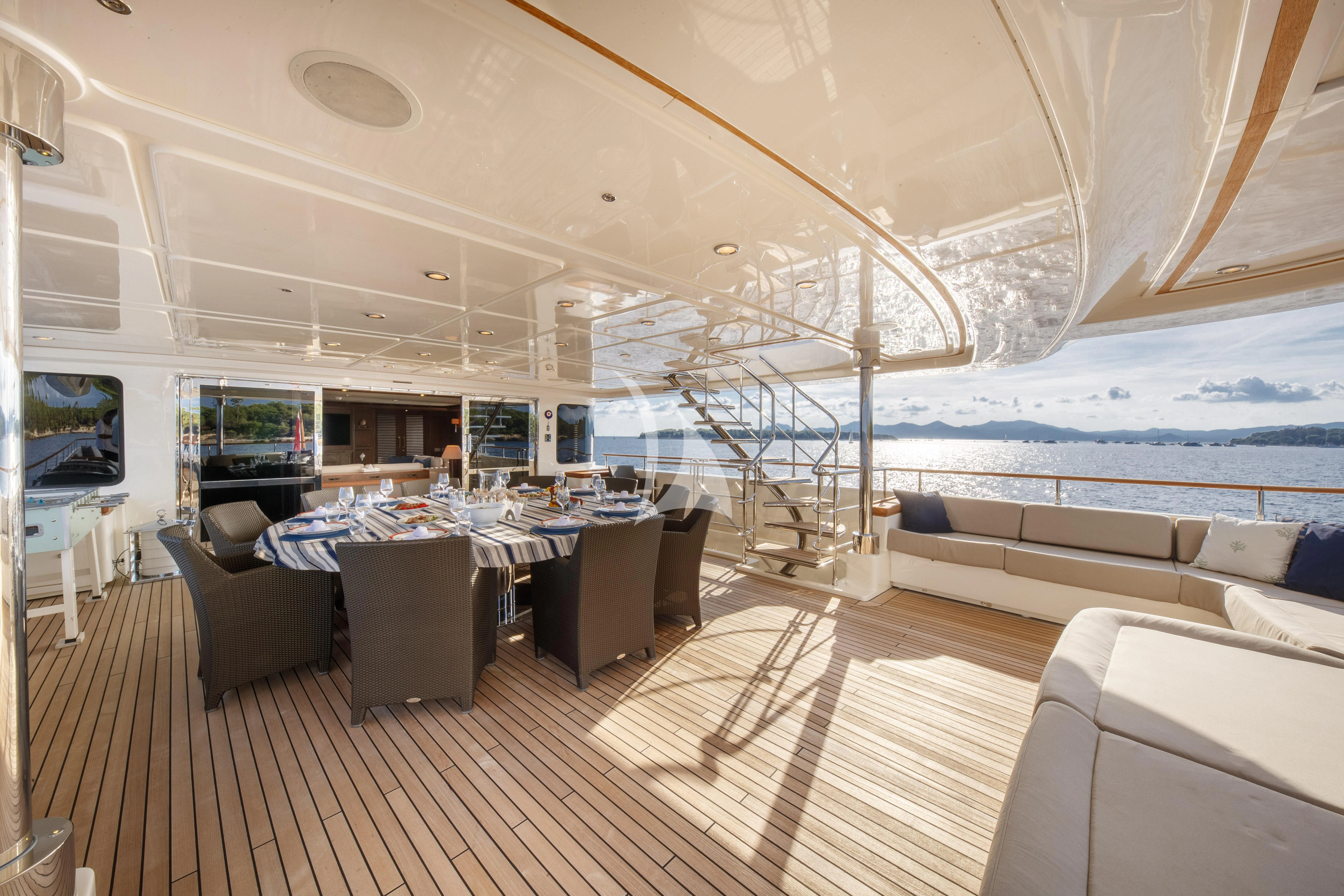 a large room with a table and chairs and a large window aboard O'LION Yacht for Sale