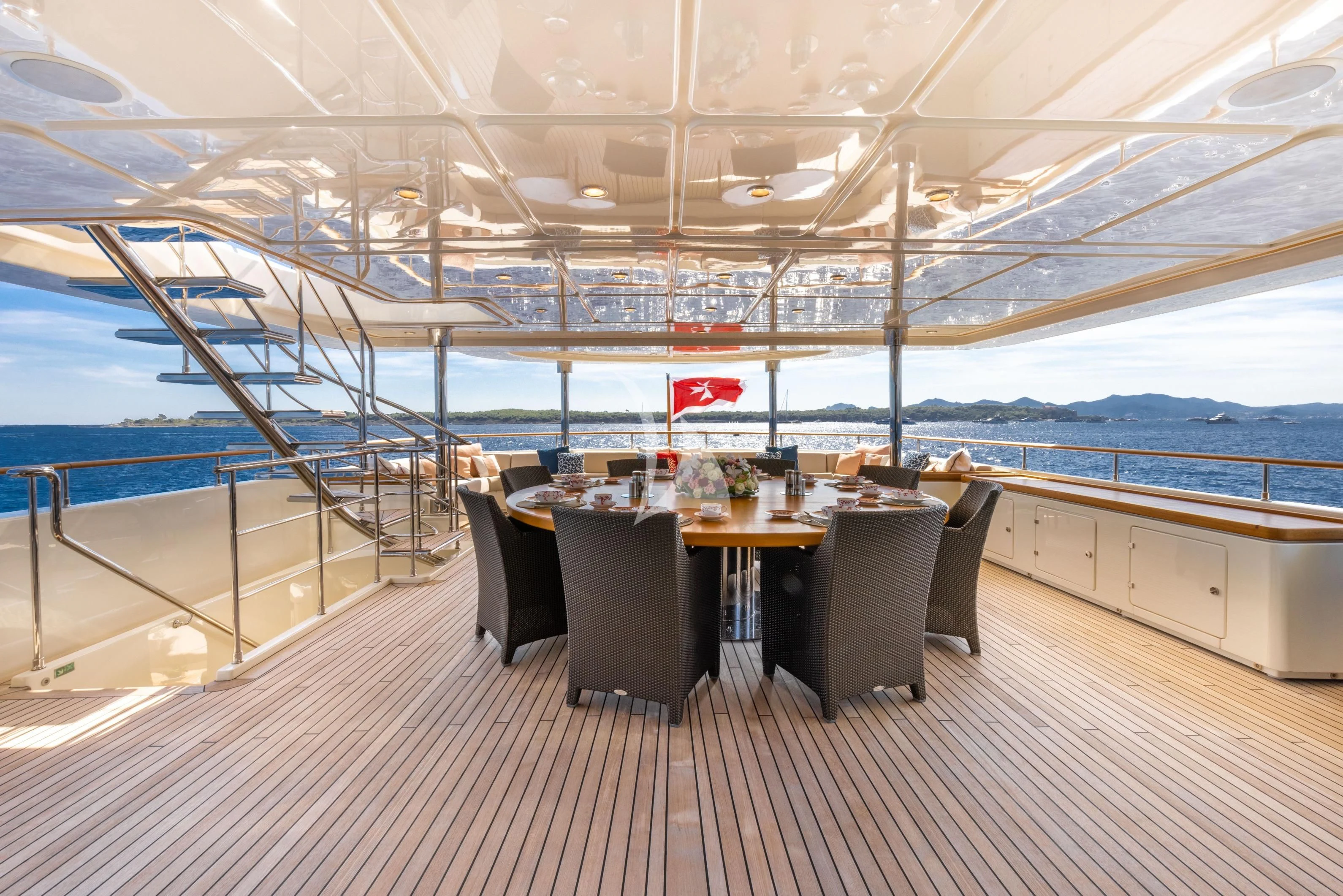 a table with chairs and a large window overlooking a large body of water aboard O'LION Yacht for Sale