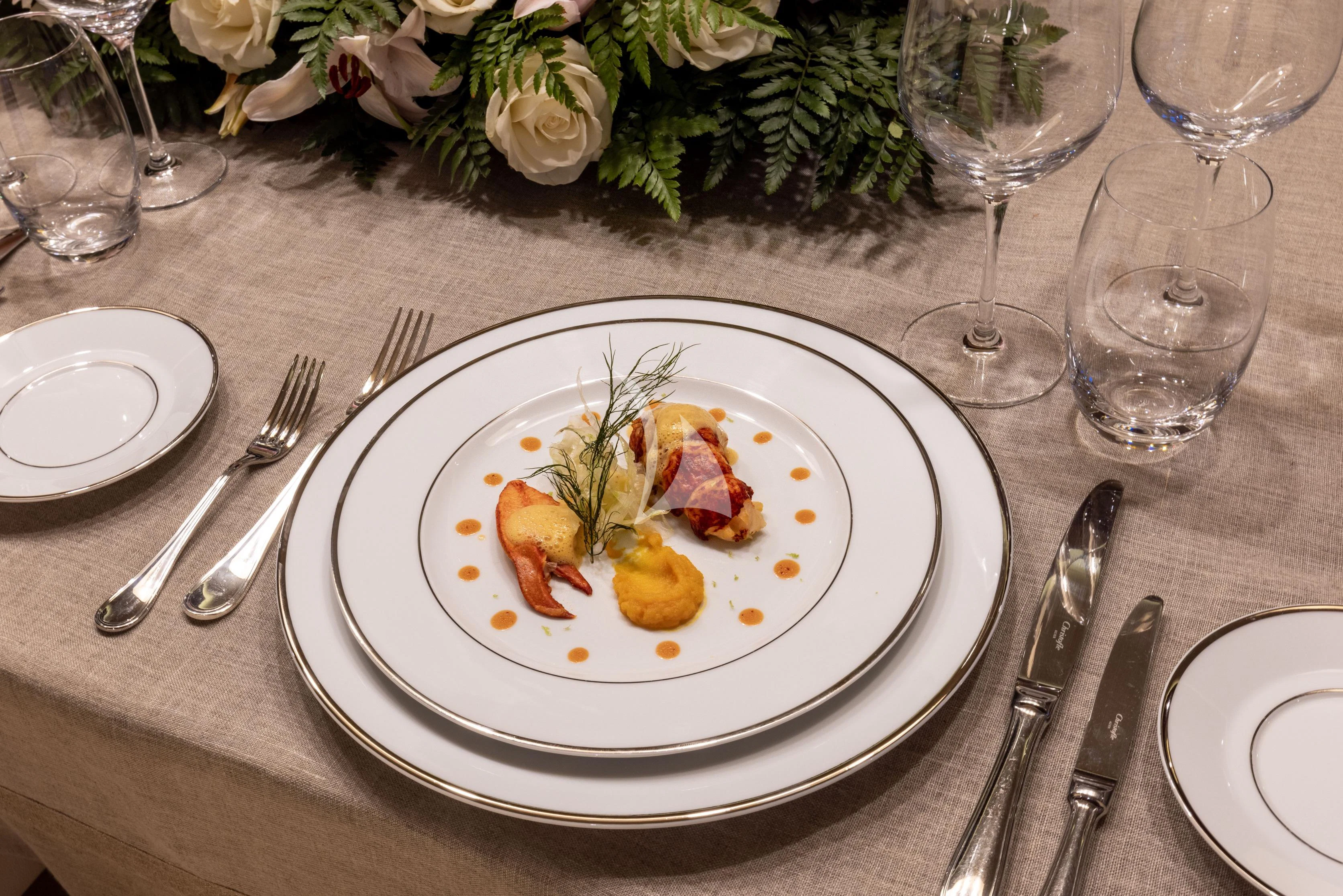 a plate of food and glasses aboard O'LION Yacht for Sale