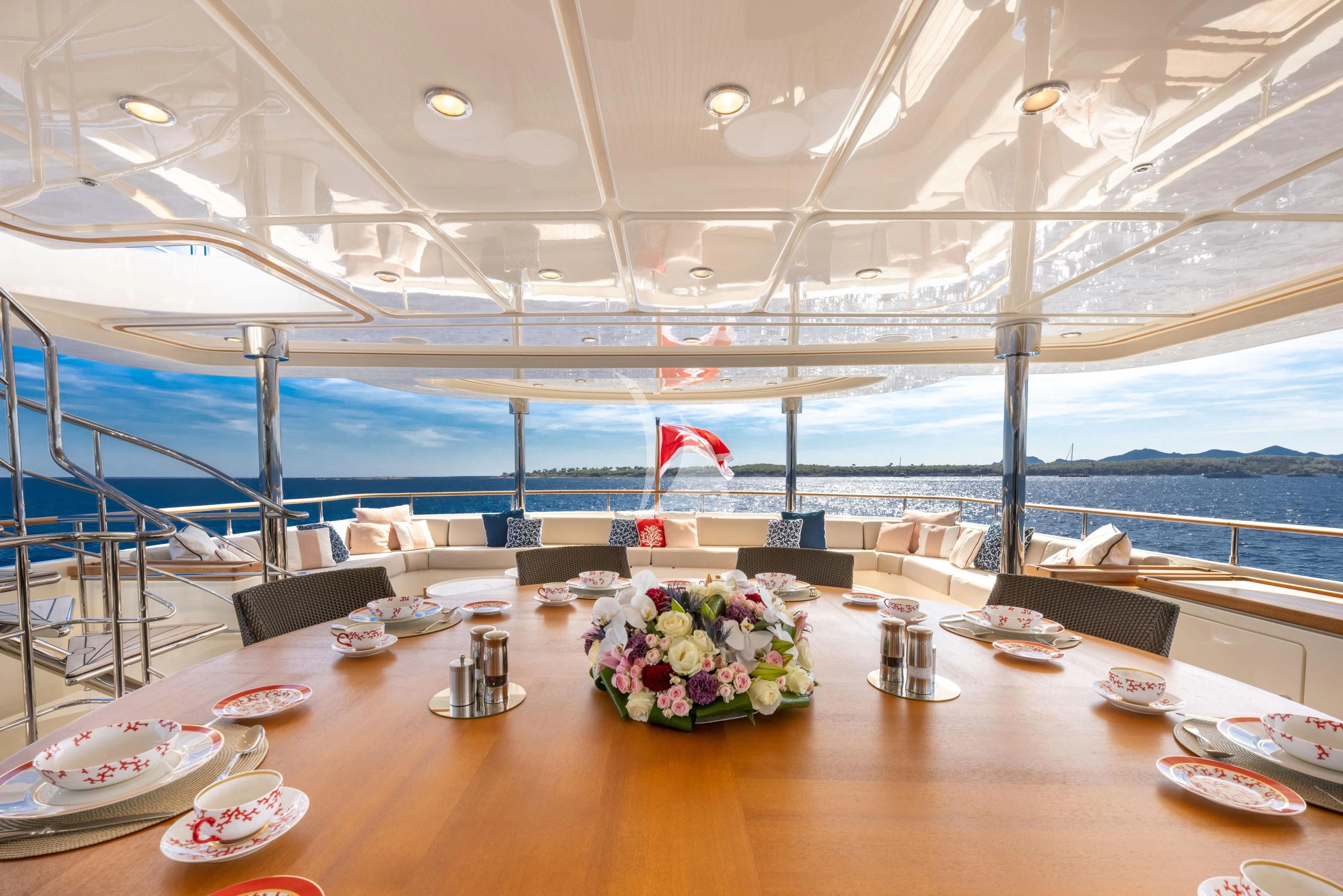 a table with plates and flowers on it aboard O'LION Yacht for Sale