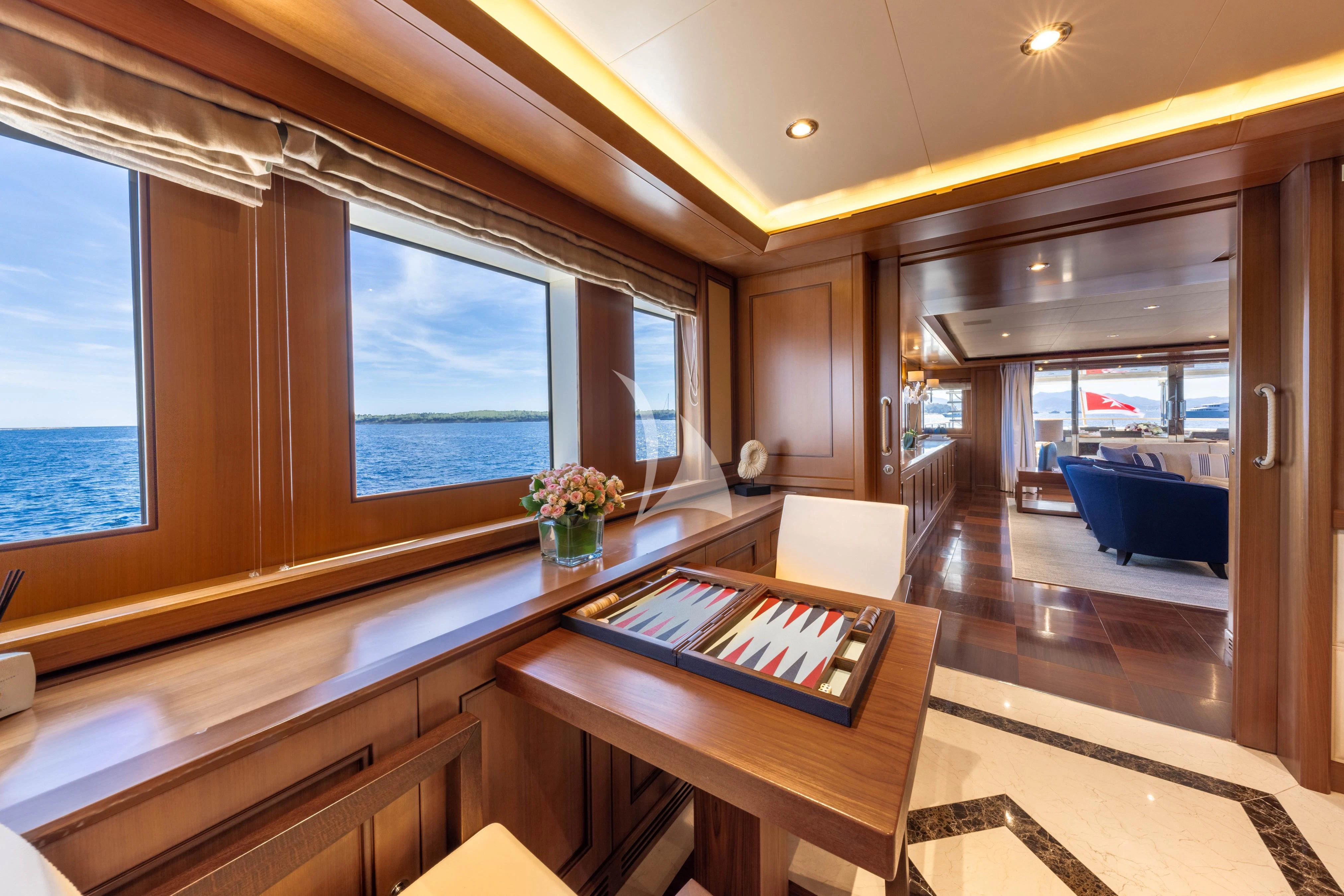 a room with a table and chairs aboard O'LION Yacht for Sale