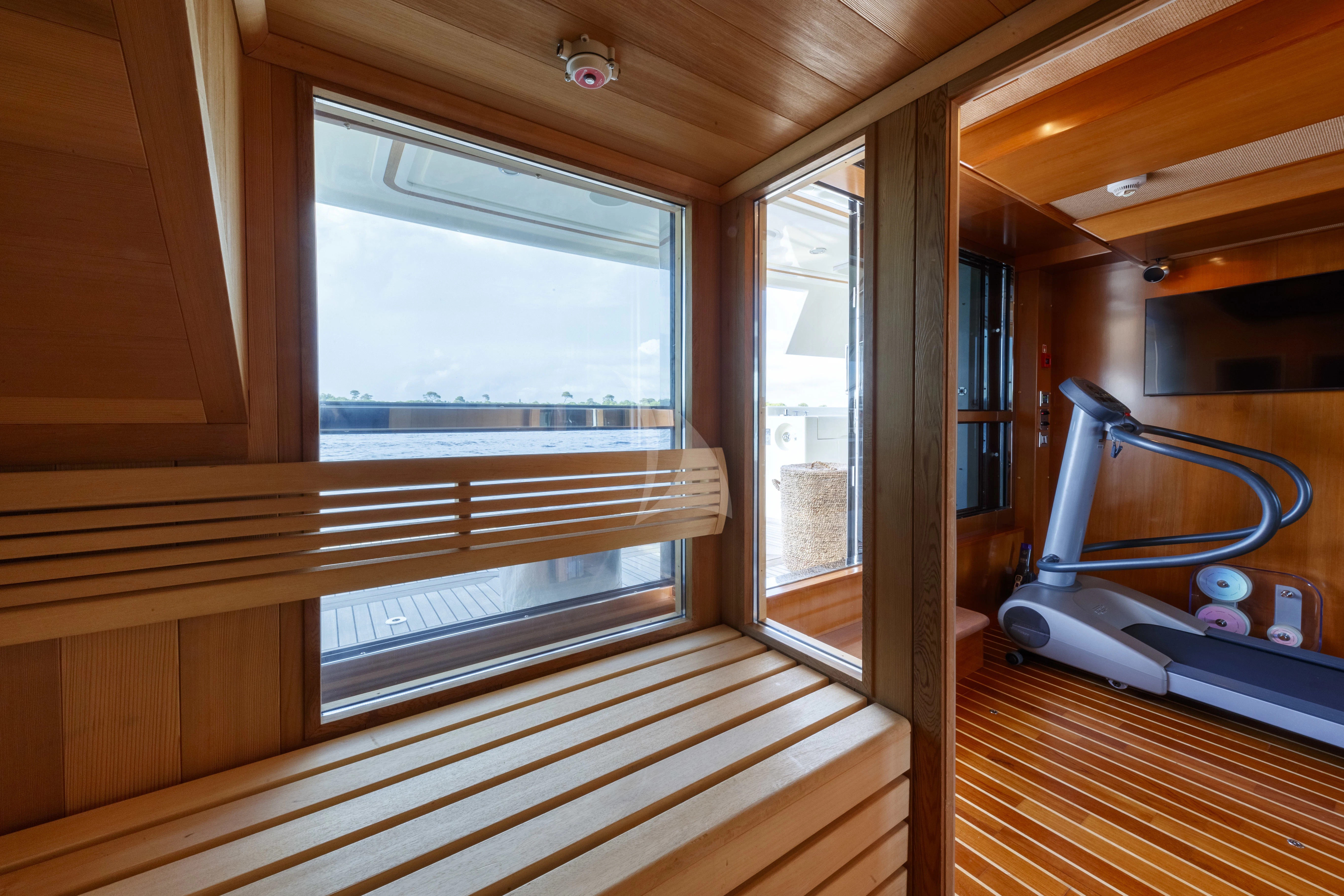 a room with a window and a shelf with books on it aboard O'LION Yacht for Sale