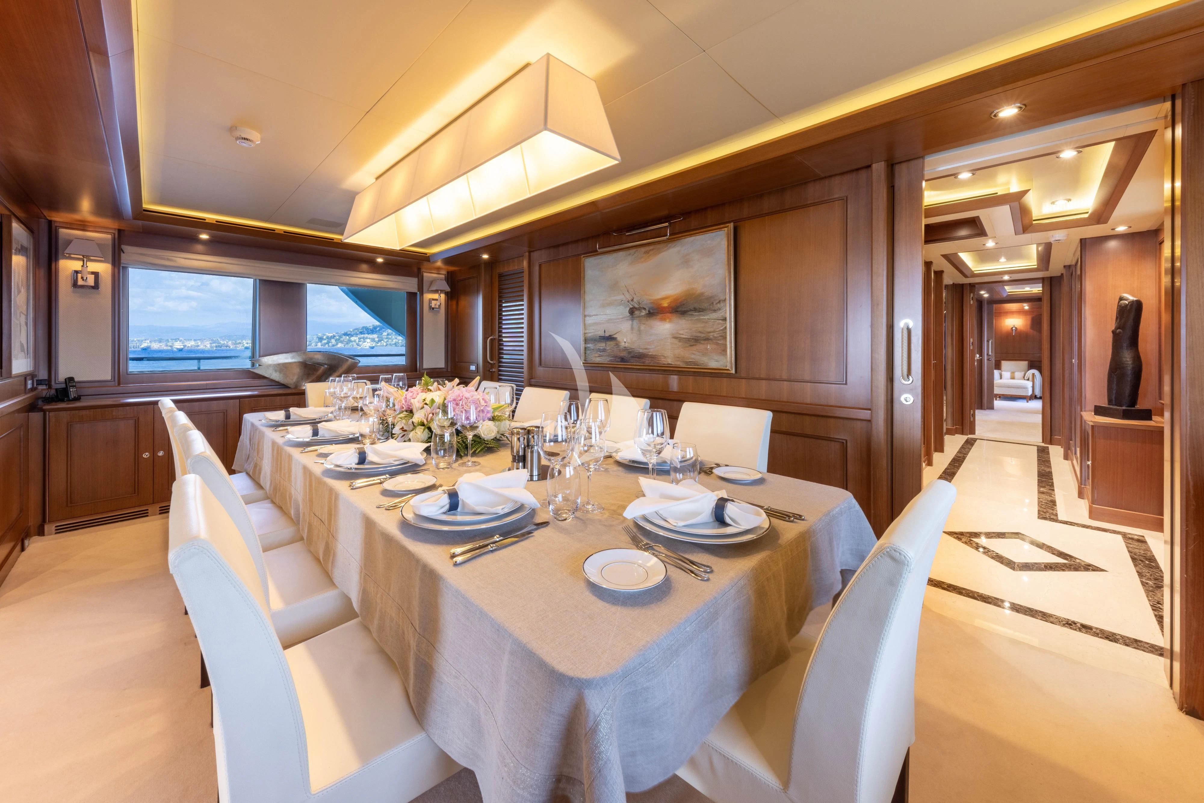 a dining table with chairs and a large screen aboard O'LION Yacht for Sale