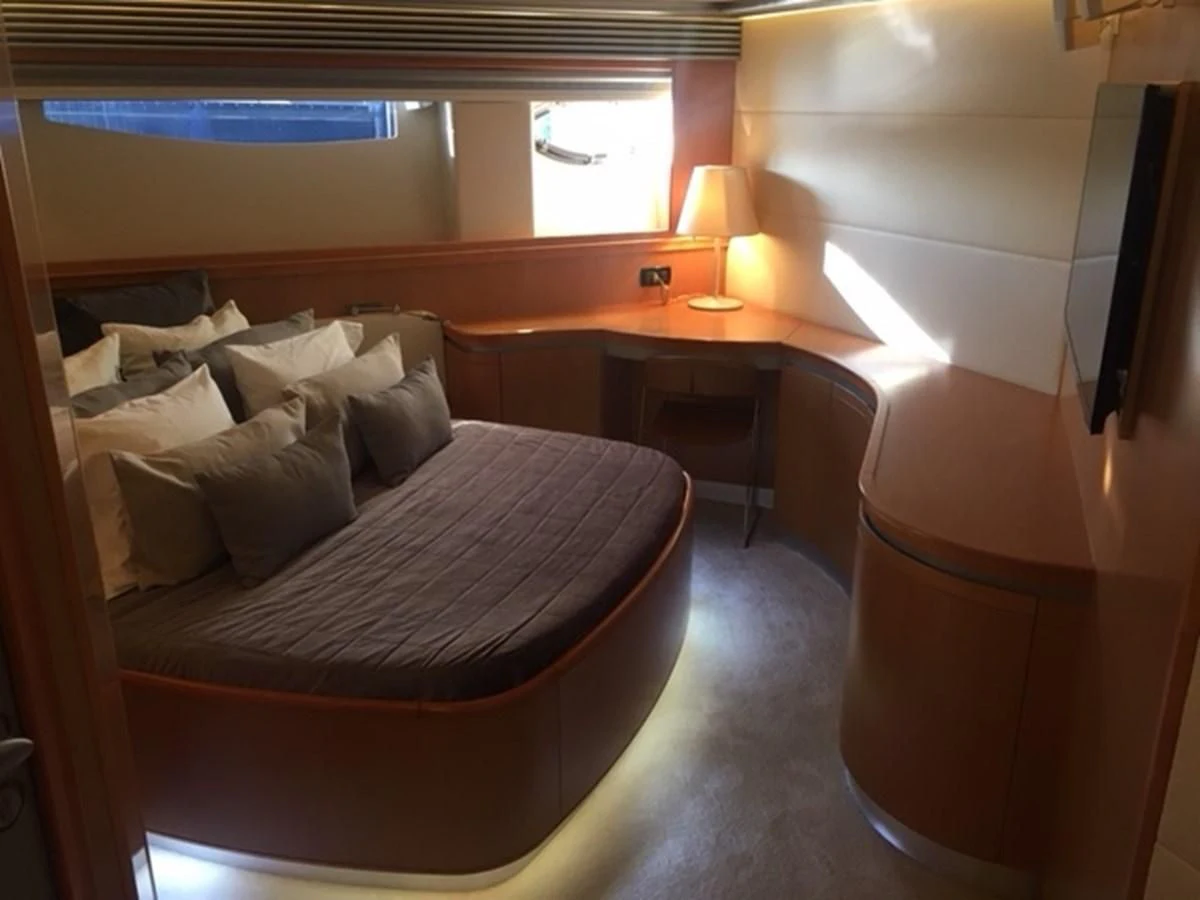 a bed with a desk and a television in a room aboard CHAKLOO Yacht for Sale