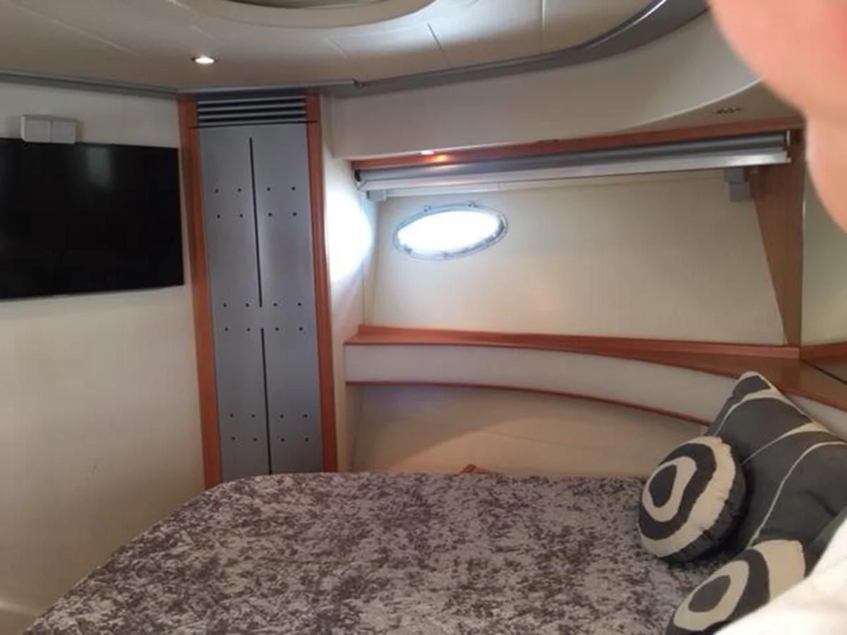 a bed with a pillow and a wood headboard aboard CHAKLOO Yacht for Sale
