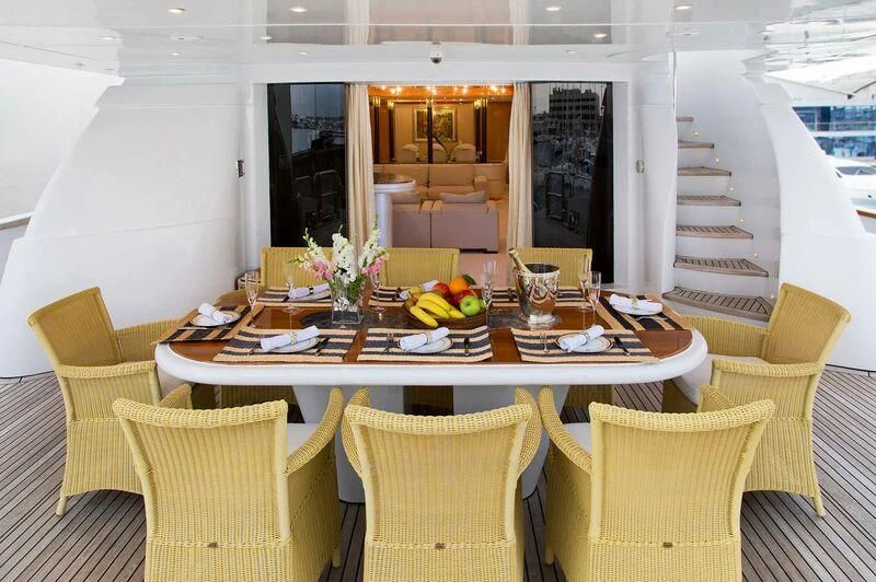 a table with chairs and a set of stairs aboard CAPRICE I Yacht for Sale