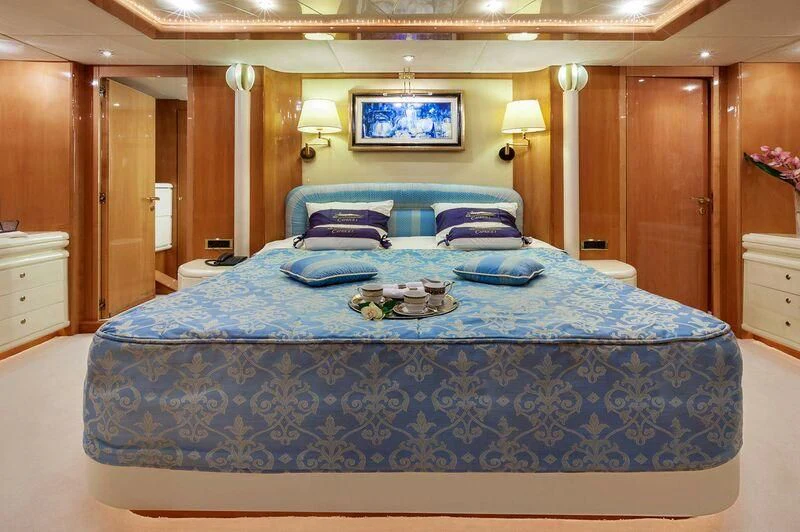 a bed with blue sheets aboard CAPRICE I Yacht for Sale