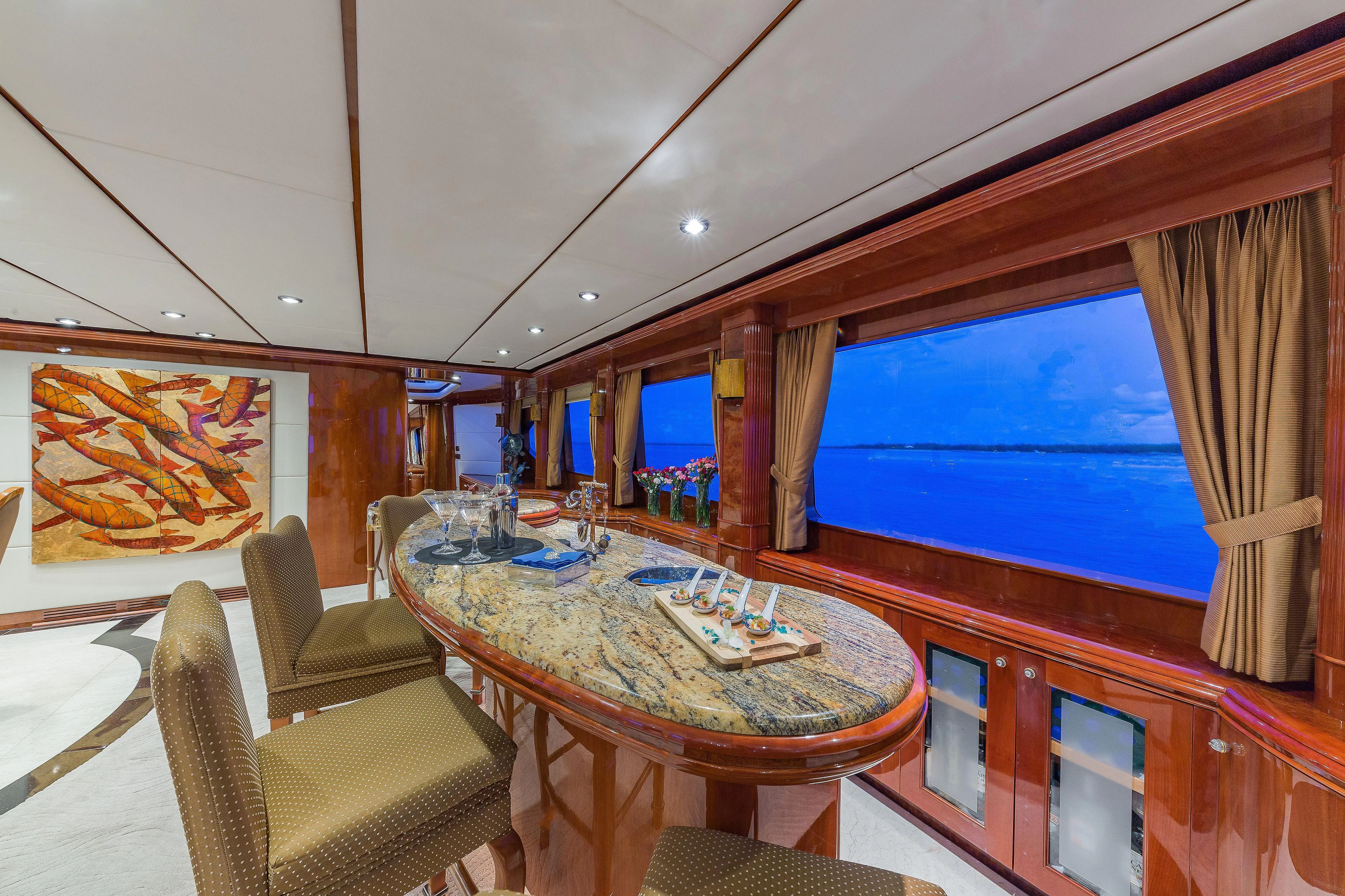 a dining table in a room aboard CAPRICE I Yacht for Sale