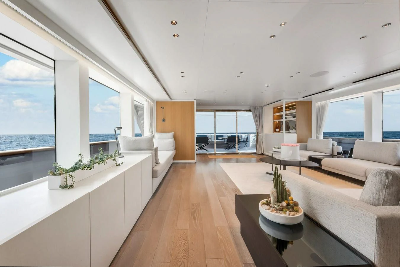 a large living room with a large window and a wood floor aboard DON'T TELL MOM Yacht for Sale