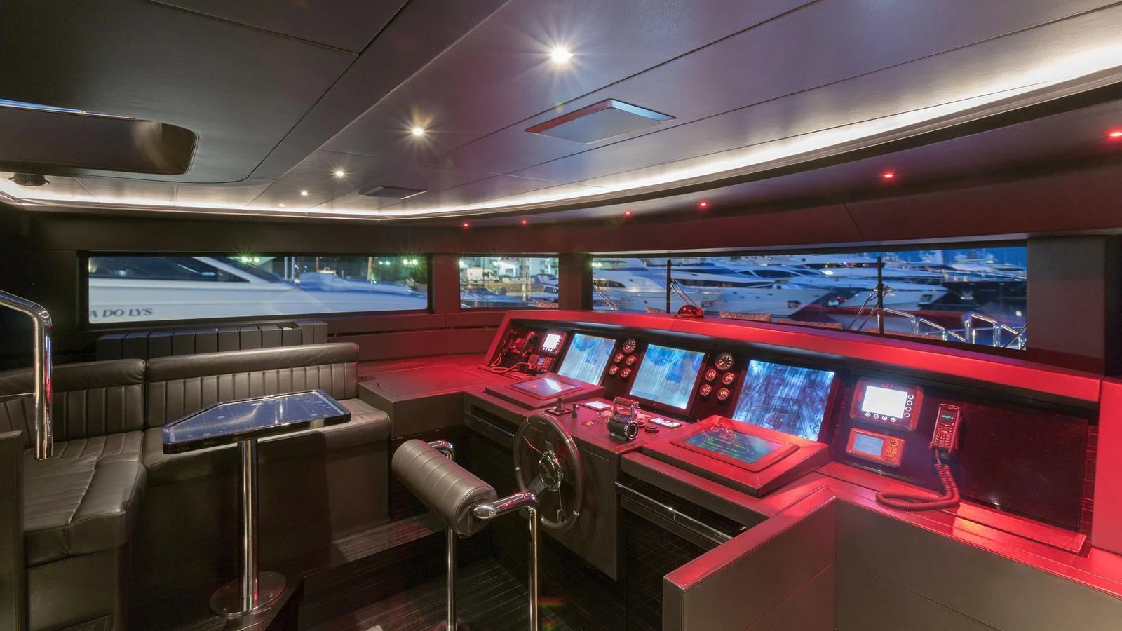 a room with red seats and tables aboard GALA Yacht for Sale