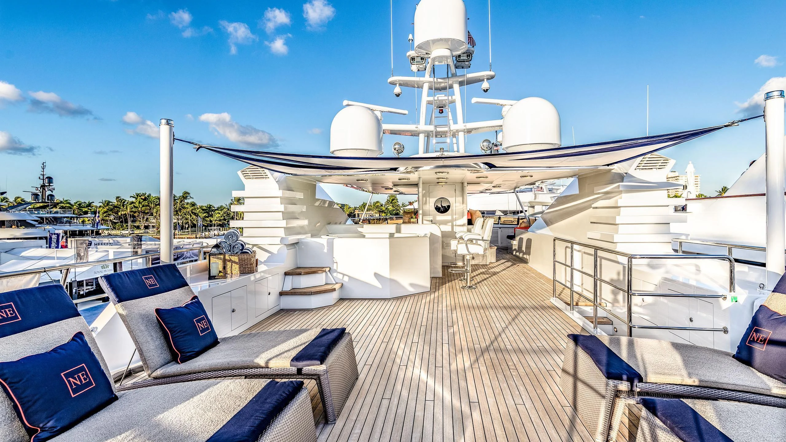 a deck with a deck and a large ship in the water aboard NEVER ENOUGH Yacht for Charter