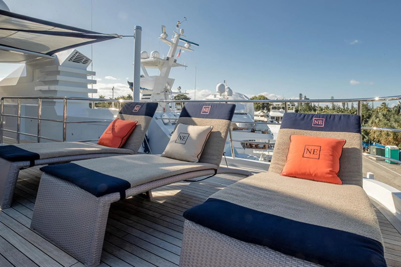 a deck with a large white boat and a deck with a large wind turbine in the background aboard NEVER ENOUGH Yacht for Charter