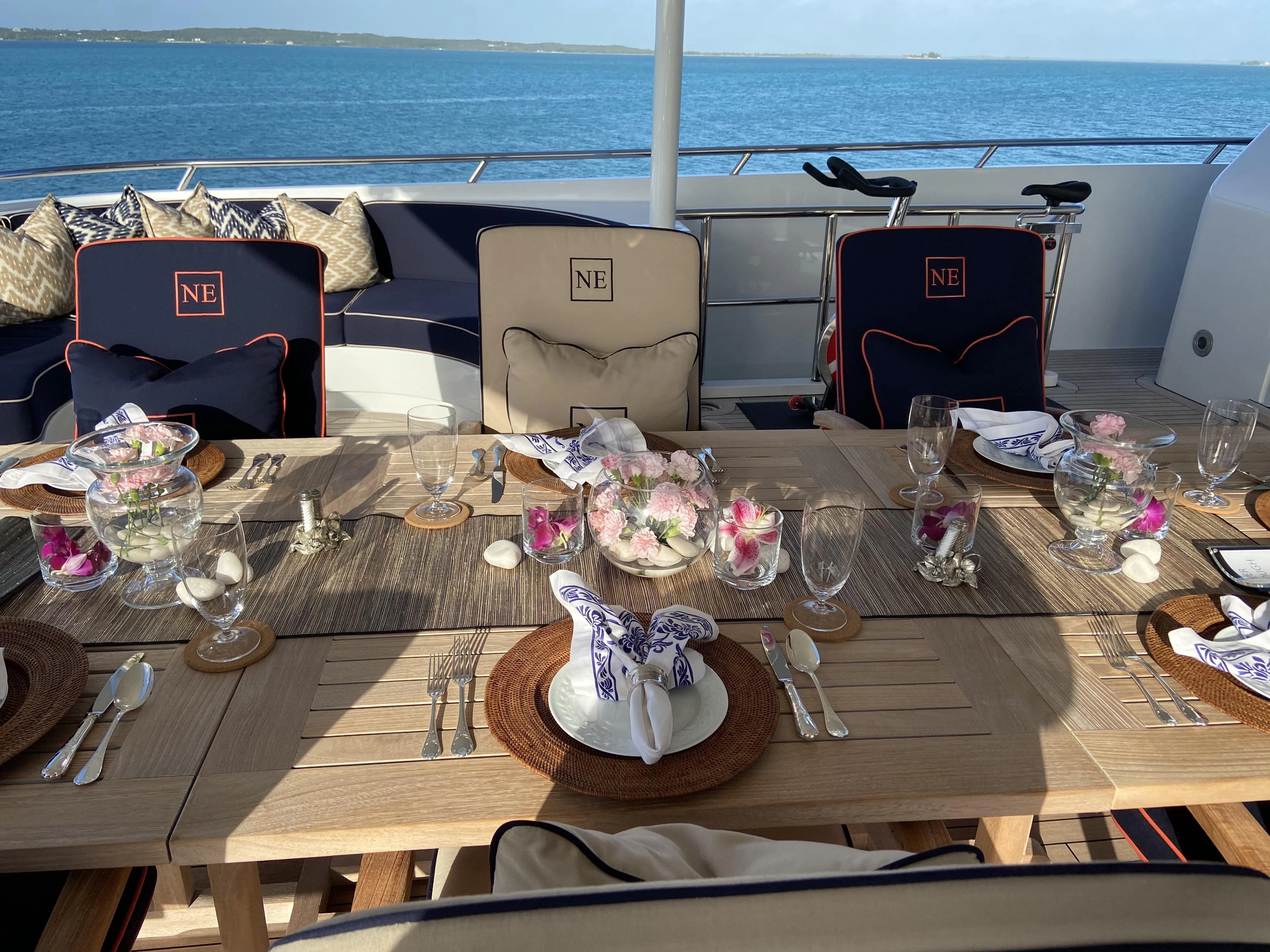 a table with glasses and flowers on it aboard NEVER ENOUGH Yacht for Charter