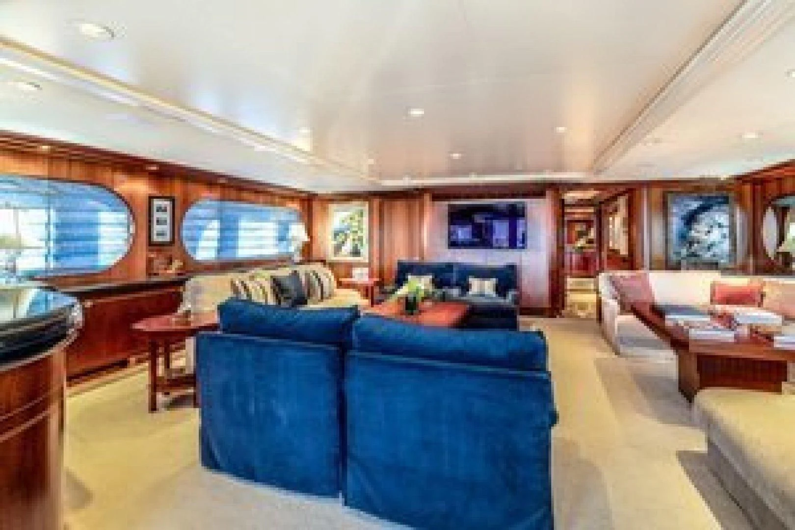 a living room with blue couches aboard NEVER ENOUGH Yacht for Charter