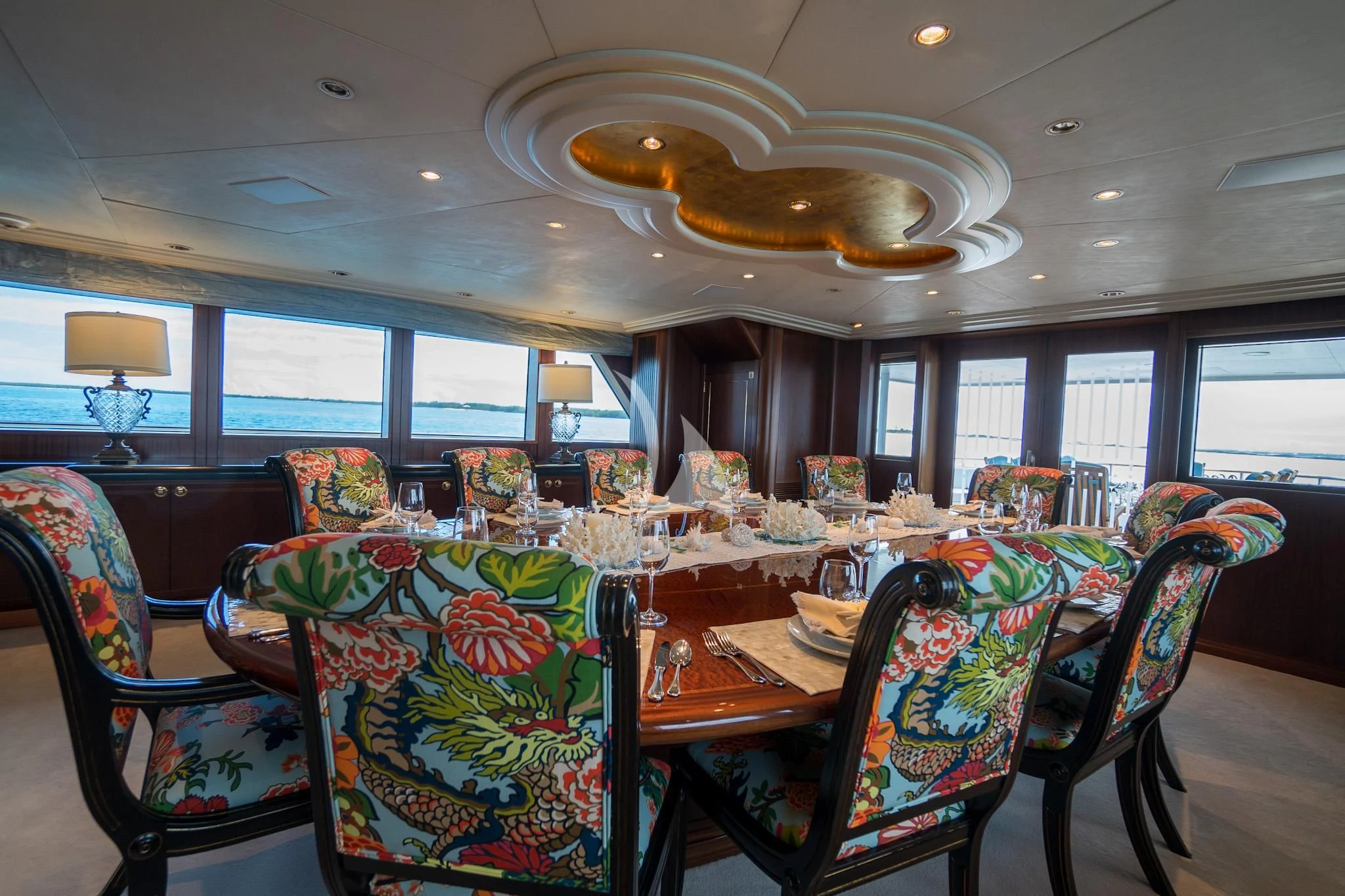 a dining room with a chandelier aboard NEVER ENOUGH Yacht for Charter
