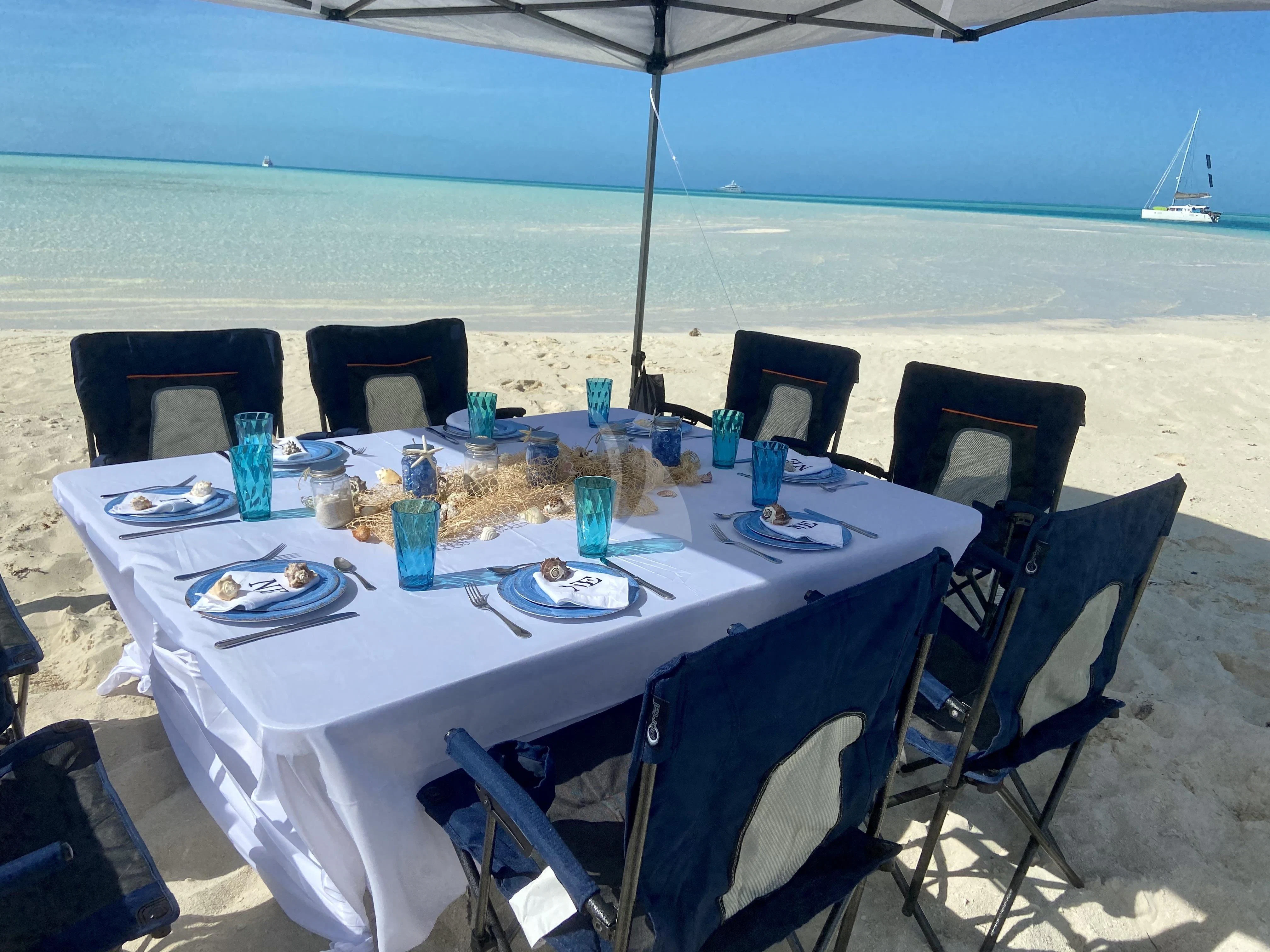 a table set for a meal on a beach aboard NEVER ENOUGH Yacht for Charter