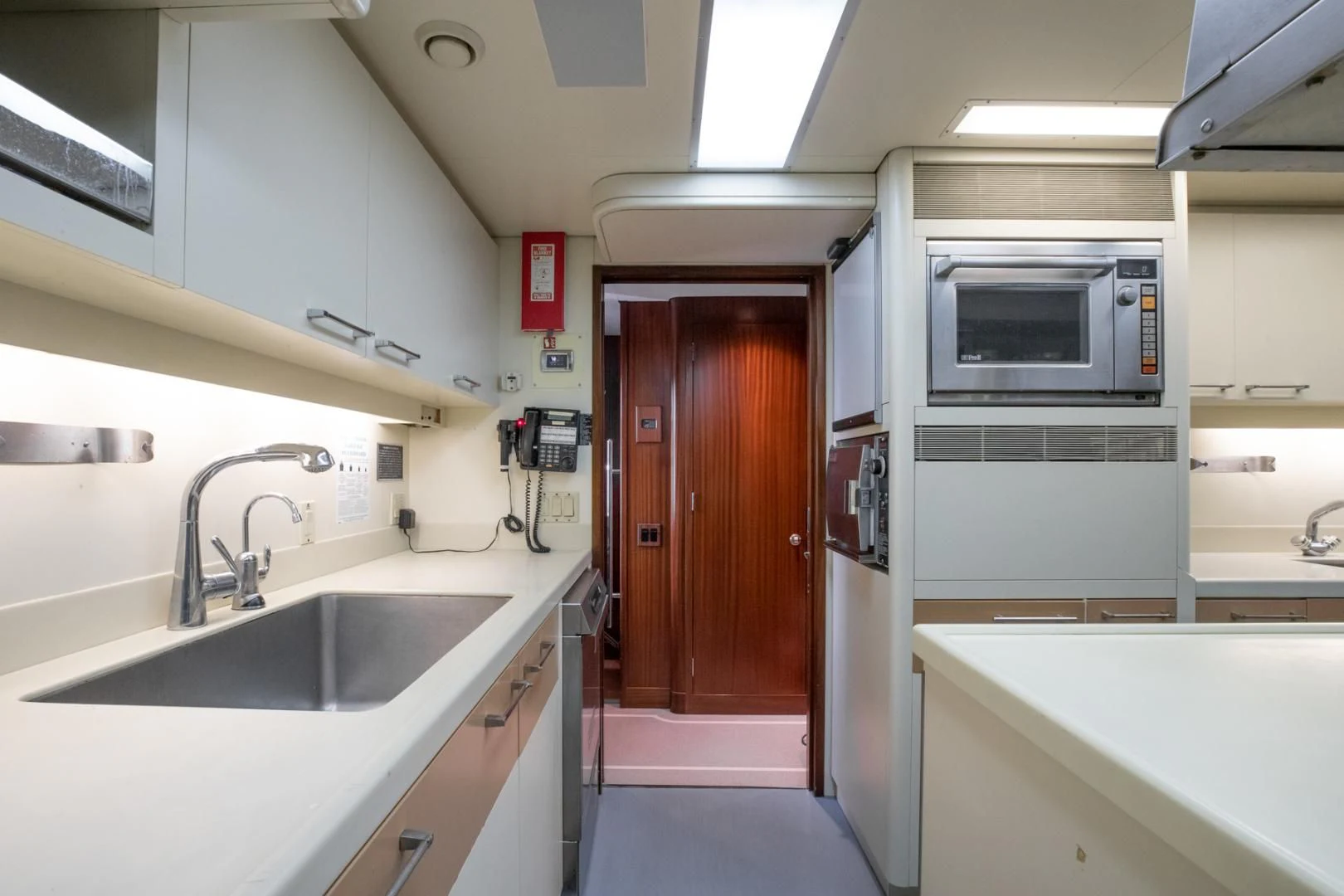 a kitchen with a sink and microwave aboard NEVER ENOUGH Yacht for Charter