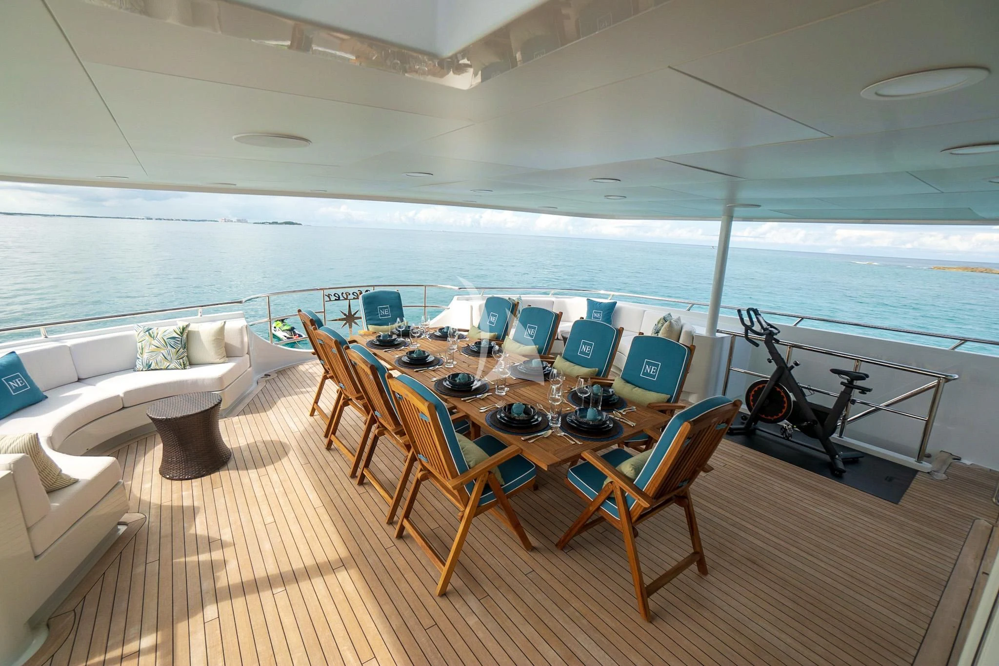 a large room with a table and chairs and a large window aboard NEVER ENOUGH Yacht for Charter