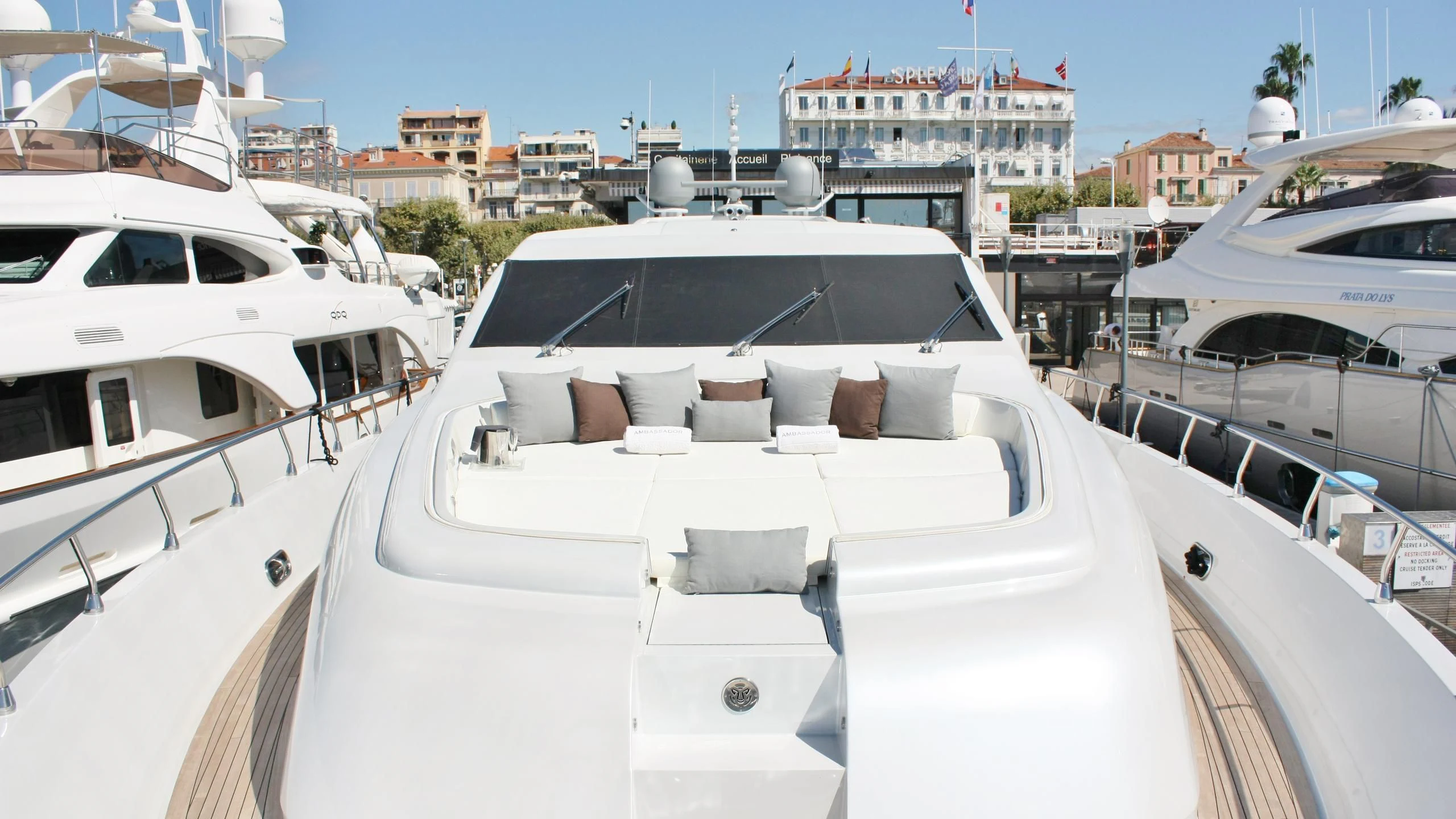 a white boat with pillows on a deck in a marina aboard JADE Yacht for Sale