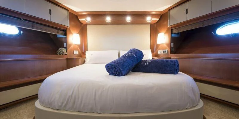 a bed with blue pillows aboard 4F Yacht for Sale