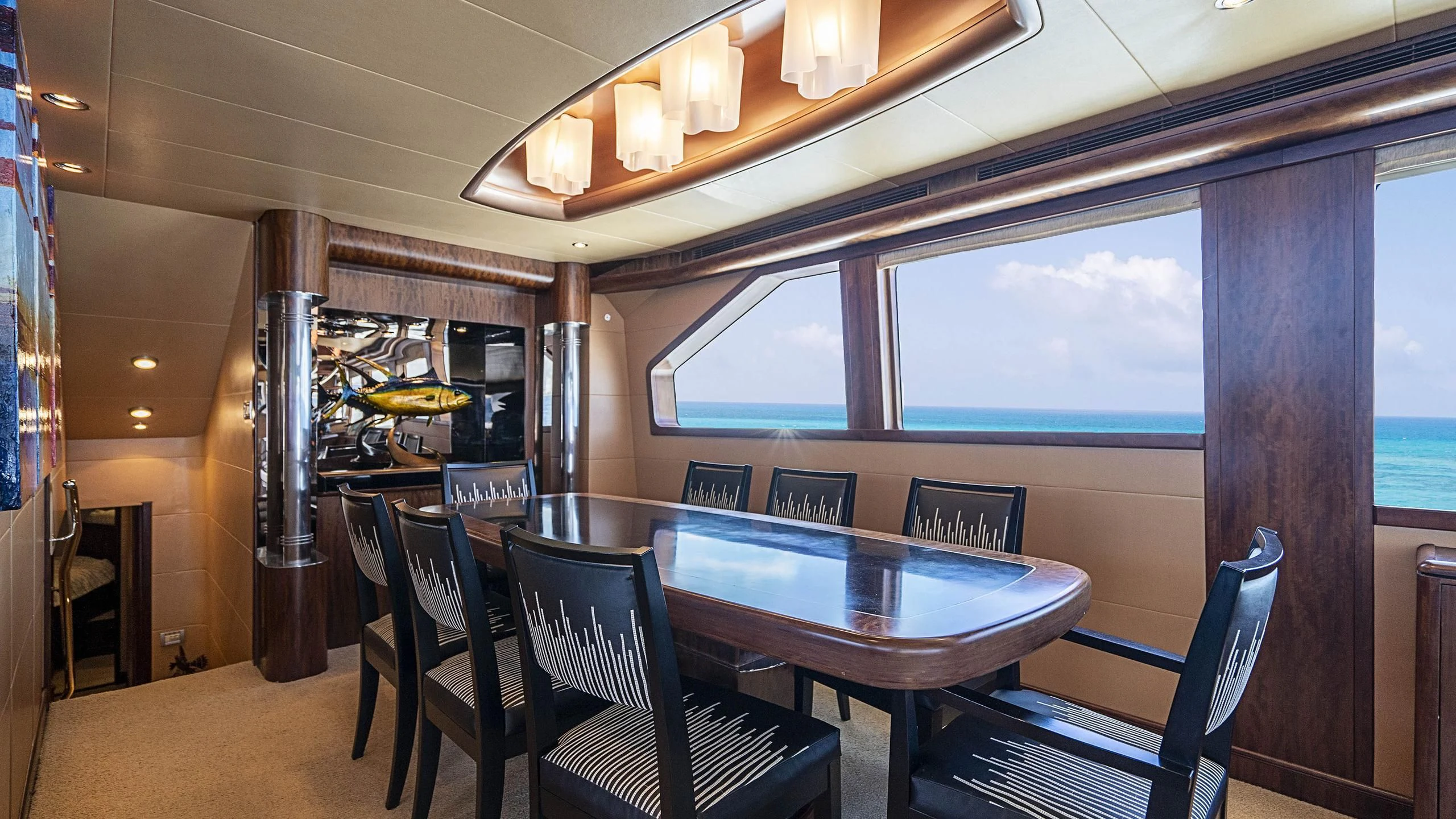 a dining table and chairs in a room with a window aboard GRAND LEGACY Yacht for Sale